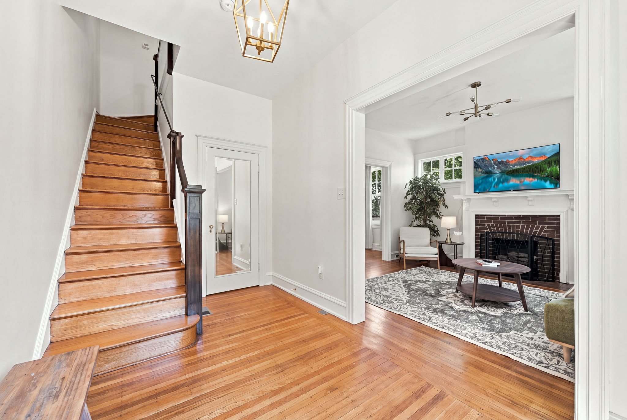 Entryway: Bright and inviting space with elegant lighting and warm wooden floors, welcoming you home!