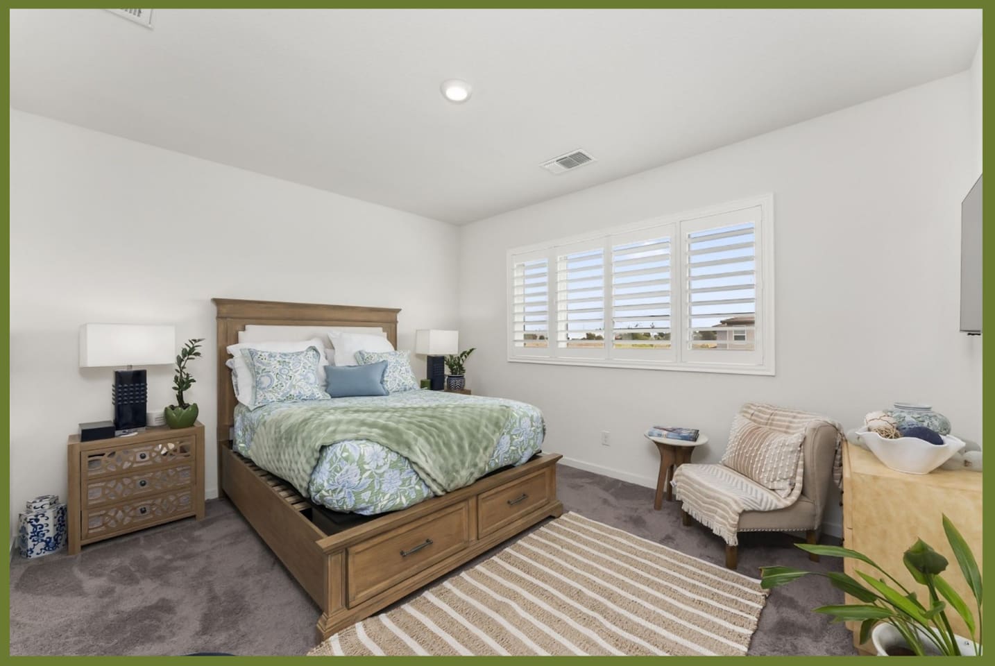 Bedroom with queen bed, dresser storage, accent chair, and bright window light for a comfortable stay.