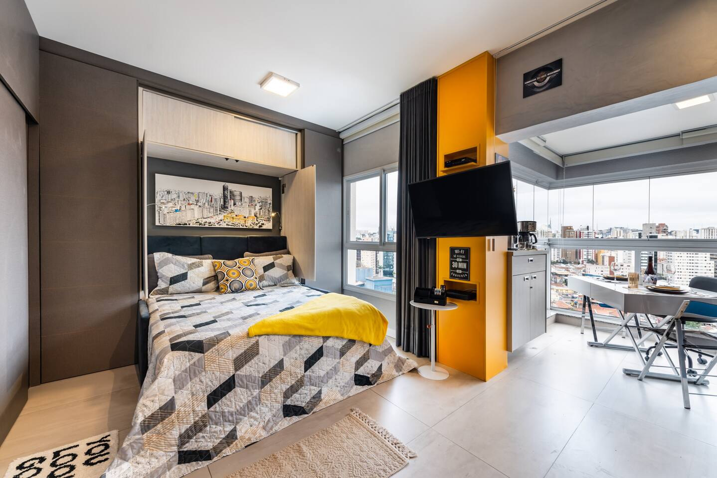 Quarto completo com cama queen-size, TV e luz natural de Pinheiros.