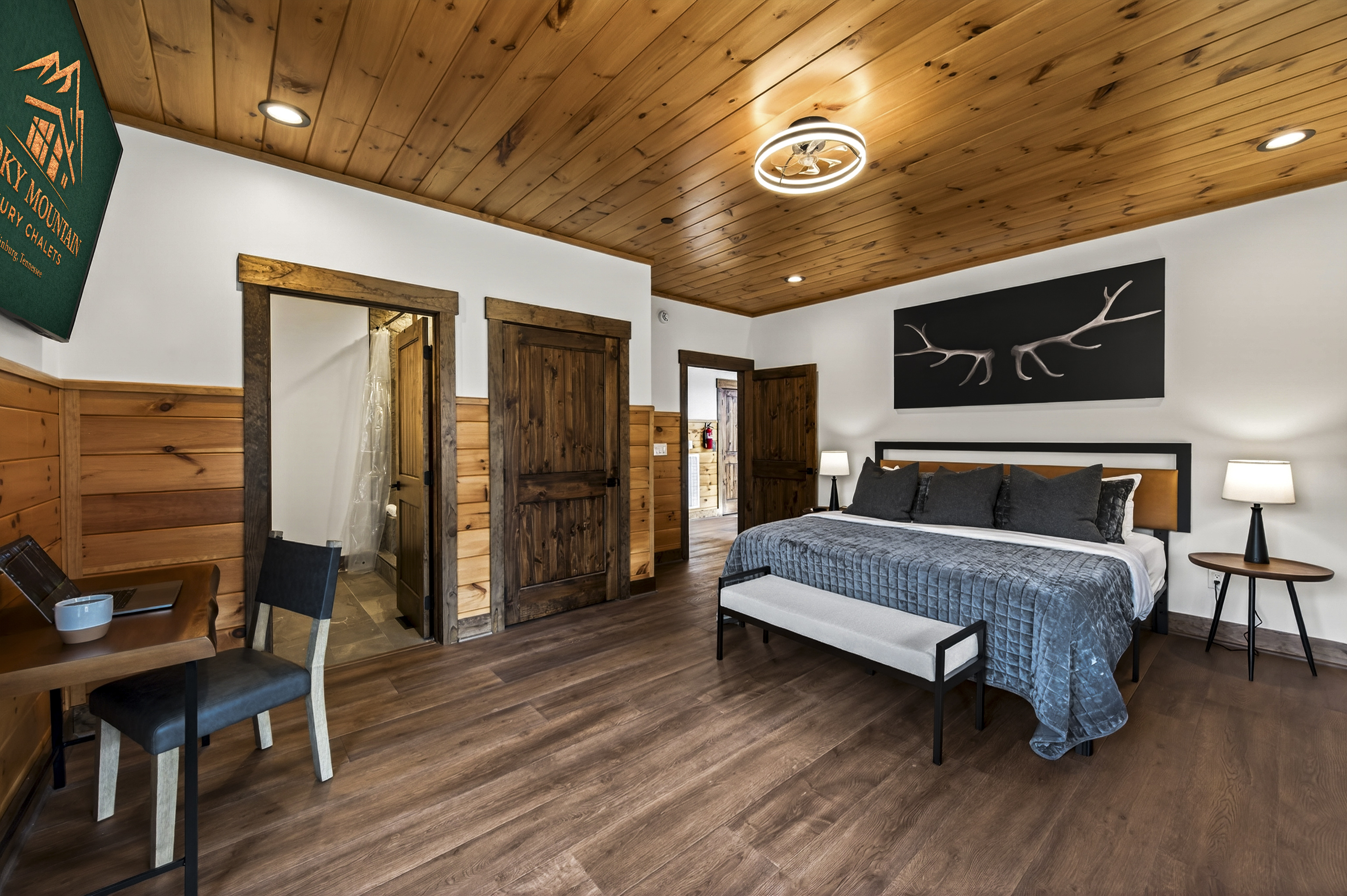 Relax in the spacious king bedroom with a large TV, dedicated desk workspace & direct deck access. Unwind in the en-suite bathroom featuring a walk-in shower with a natural river rock floor, bringing  the Smoky Mountains indoors for a spa retreat.