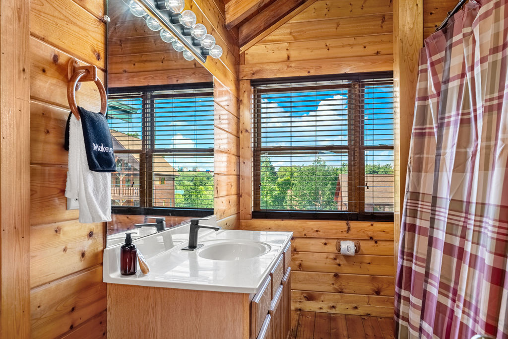 This ensuite bathroom features a tub and shower combo that blends rustic charm with everyday comfort&mdash;ideal for rinsing off the day or soaking in the serenity of your mountain escape.