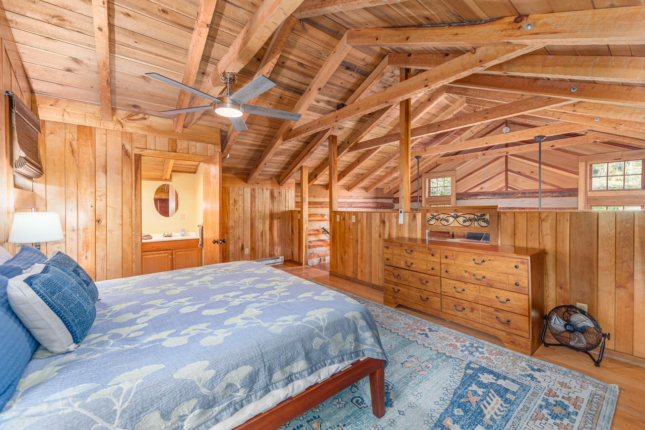 With exposed wood beams, the loft bedroom features a king size bed.