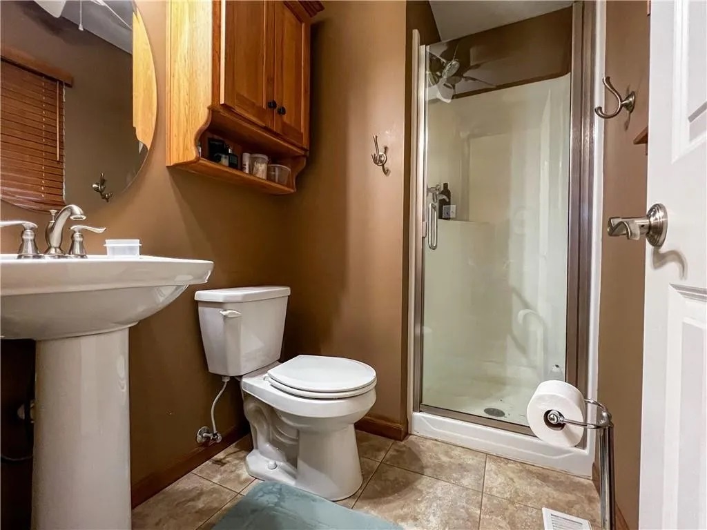 This bathroom features a walk-in shower and a straightforward layout, offering a convenient and comfortable place to start or end your day.