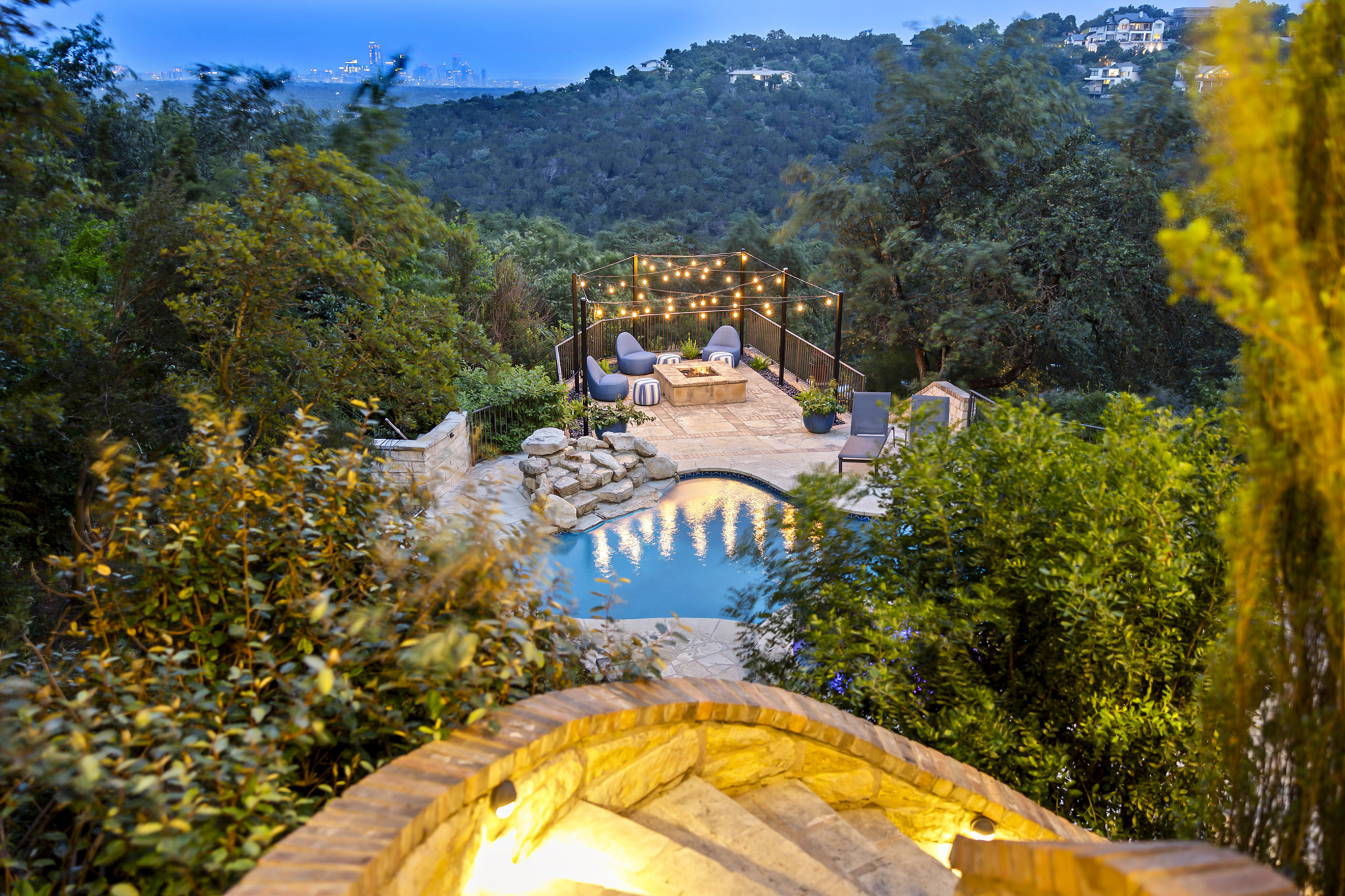 Hillside private pool surrounded by lush trees.