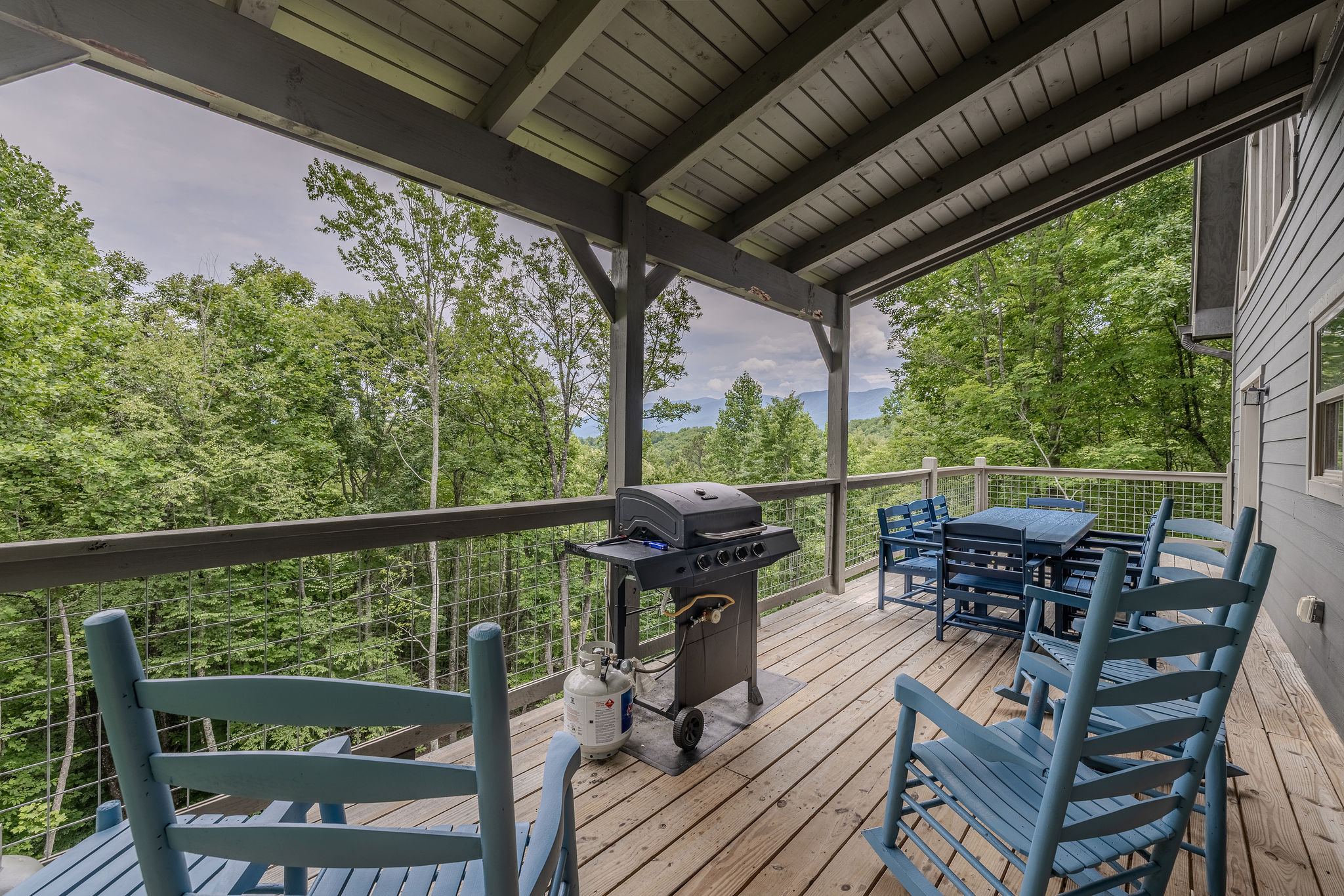 Enjoy fresh mountain air and wooded views from the covered deck.