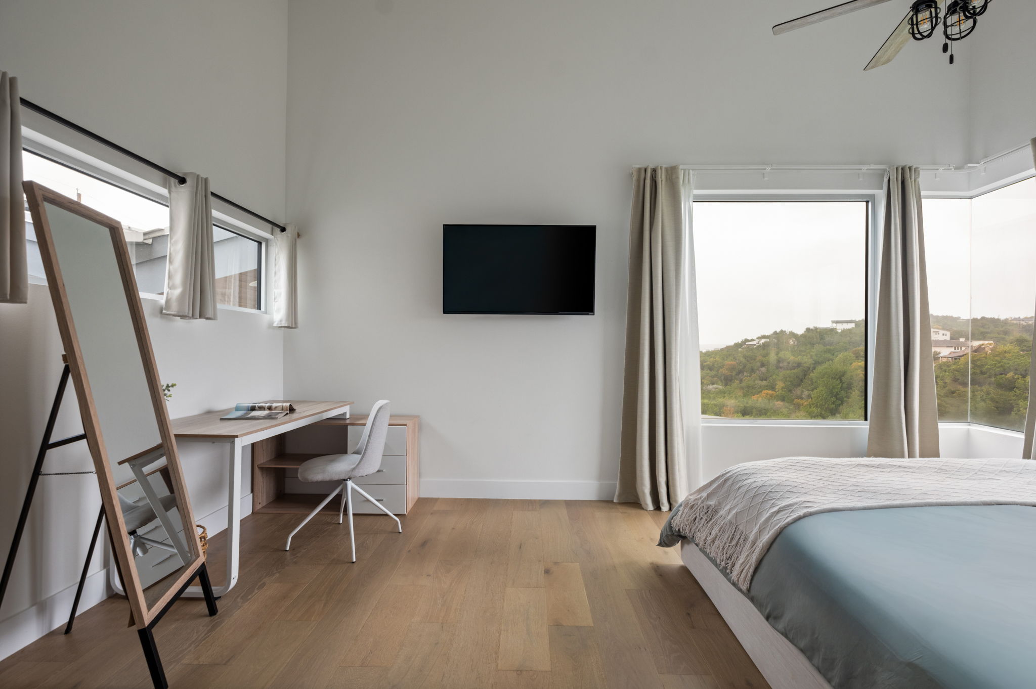 Comfortable primary bedroom with workspace and smart TV