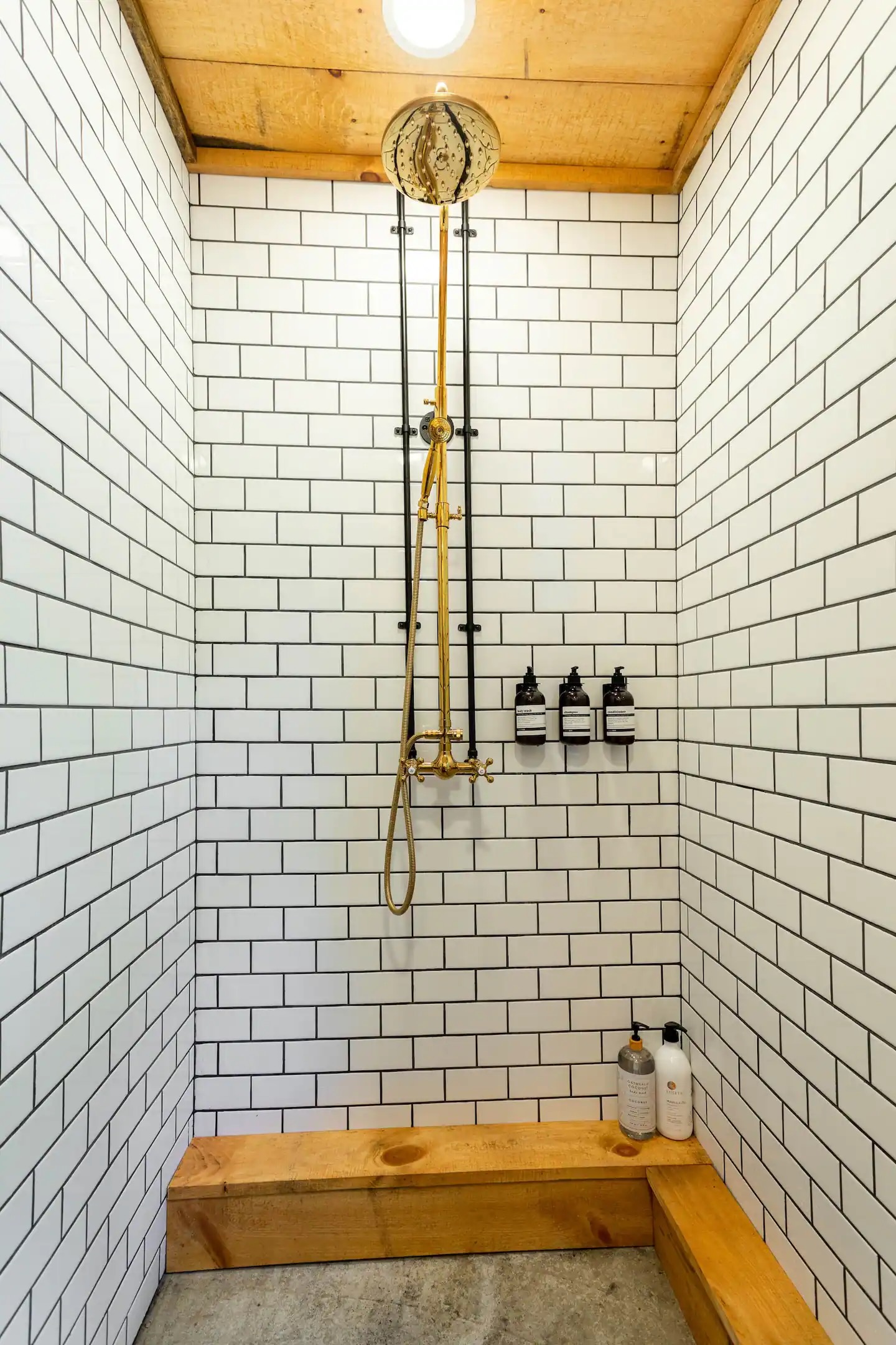 Downstairs bathroom has open concept shower with rain shower head plus handheld attachment.