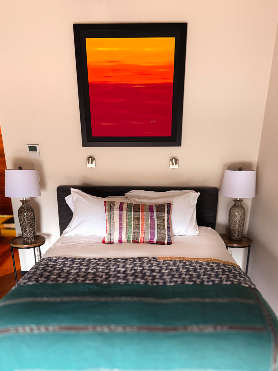 Bedroom Three at Sunset Falls &mdash; queen bed beneath sunset painting, ground floor
