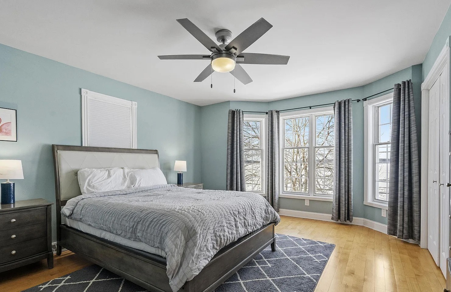 Relax in this peaceful queen bedroom featuring calming seafoam green walls, oversized lakeview windows filled with natural light, desk+chair, and two large closets for plenty of storage.