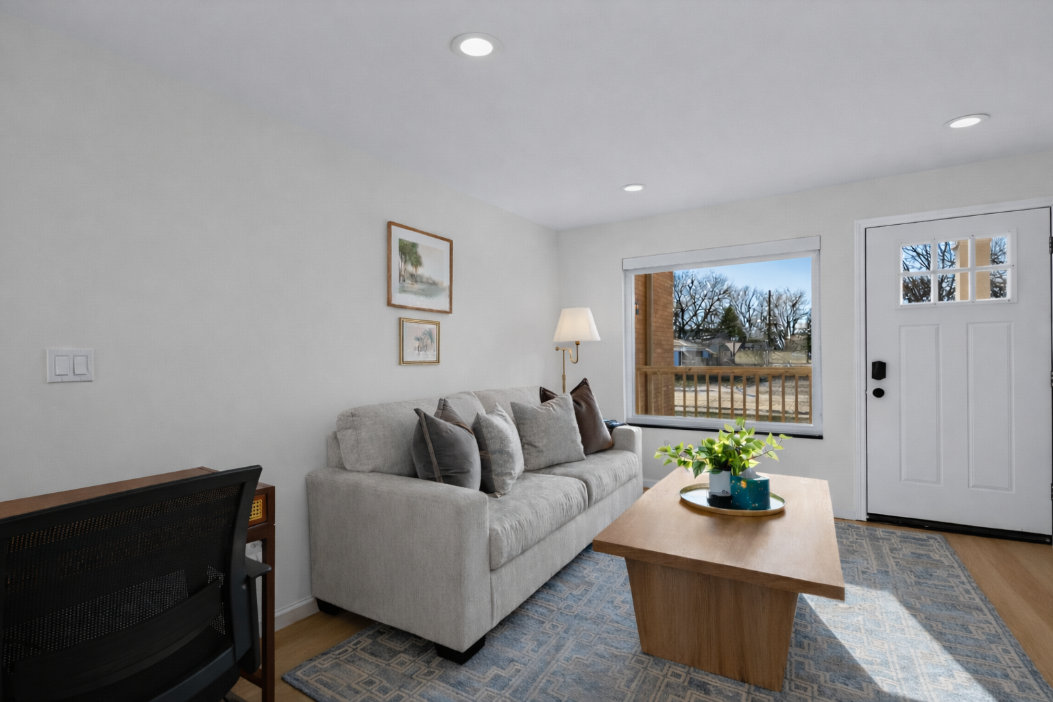 Bright, modern living room with plush seating, clean lines, and a large window that fills the space with natural light and a warm, welcoming feel.