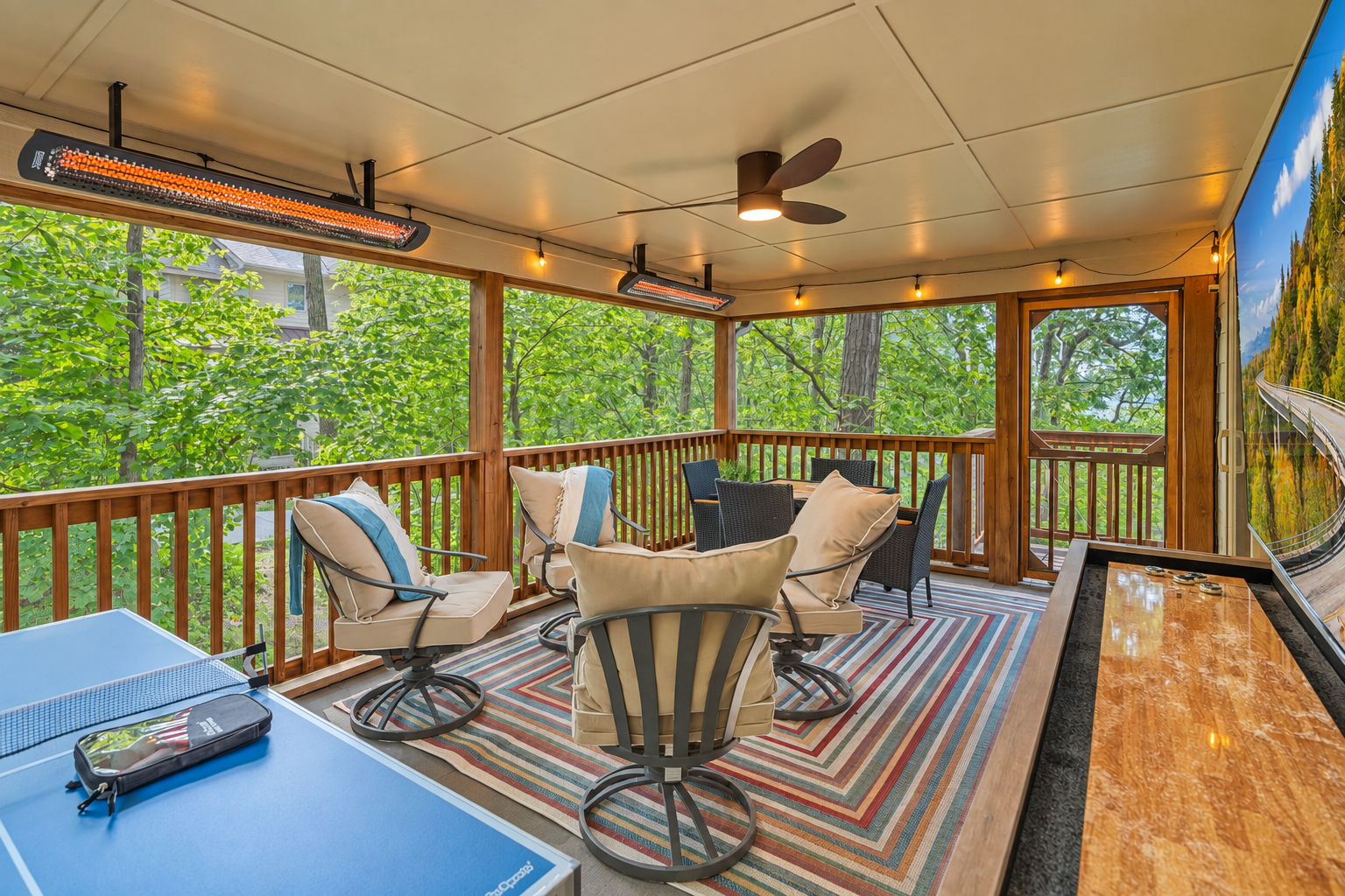 Treehouse vibes meet upscale amenities — shuffleboard, ping pong, and radiant warmth make this screened porch a year-round haven.