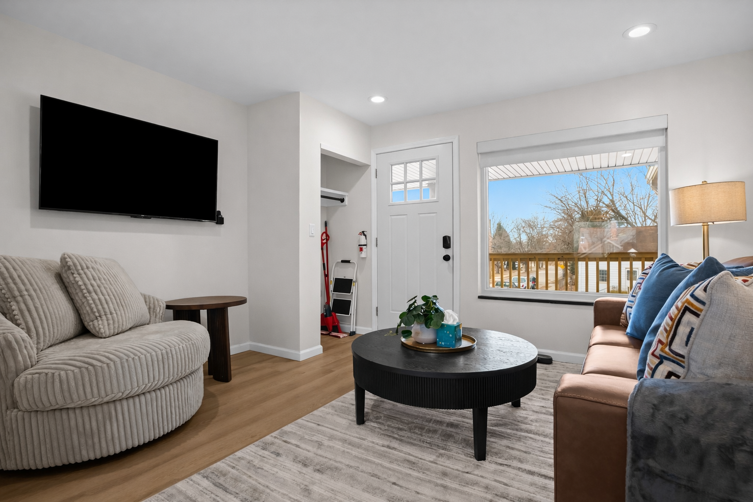 Relax in this bright, modern living room featuring cozy seating, a smart TV, and natural light—an inviting space to unwind and feel right at home.