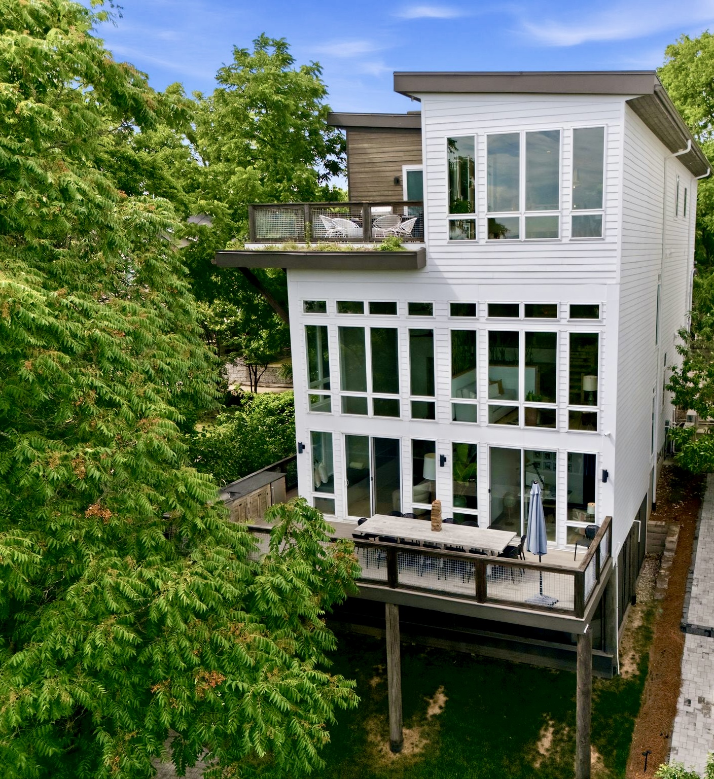 Striking multi-story exterior w/ walls of glass & a verdant rooftop garden above the treetops.
