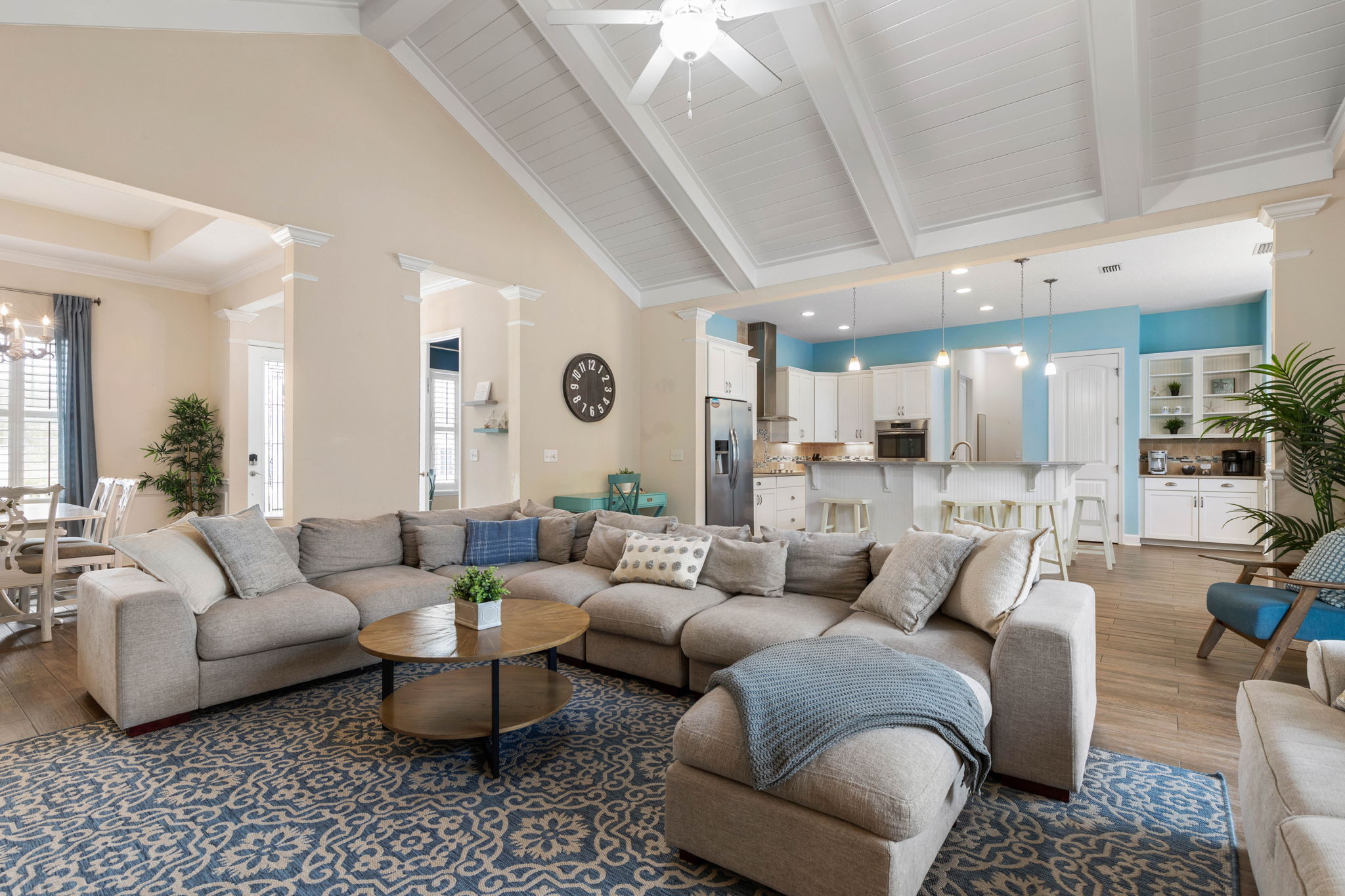 Gather beneath soaring ceilings, sink into the oversized sectional, and let the day slow down—coffee at the island, cards at the table, and everyone together in one bright, breezy space that feels made for connection.