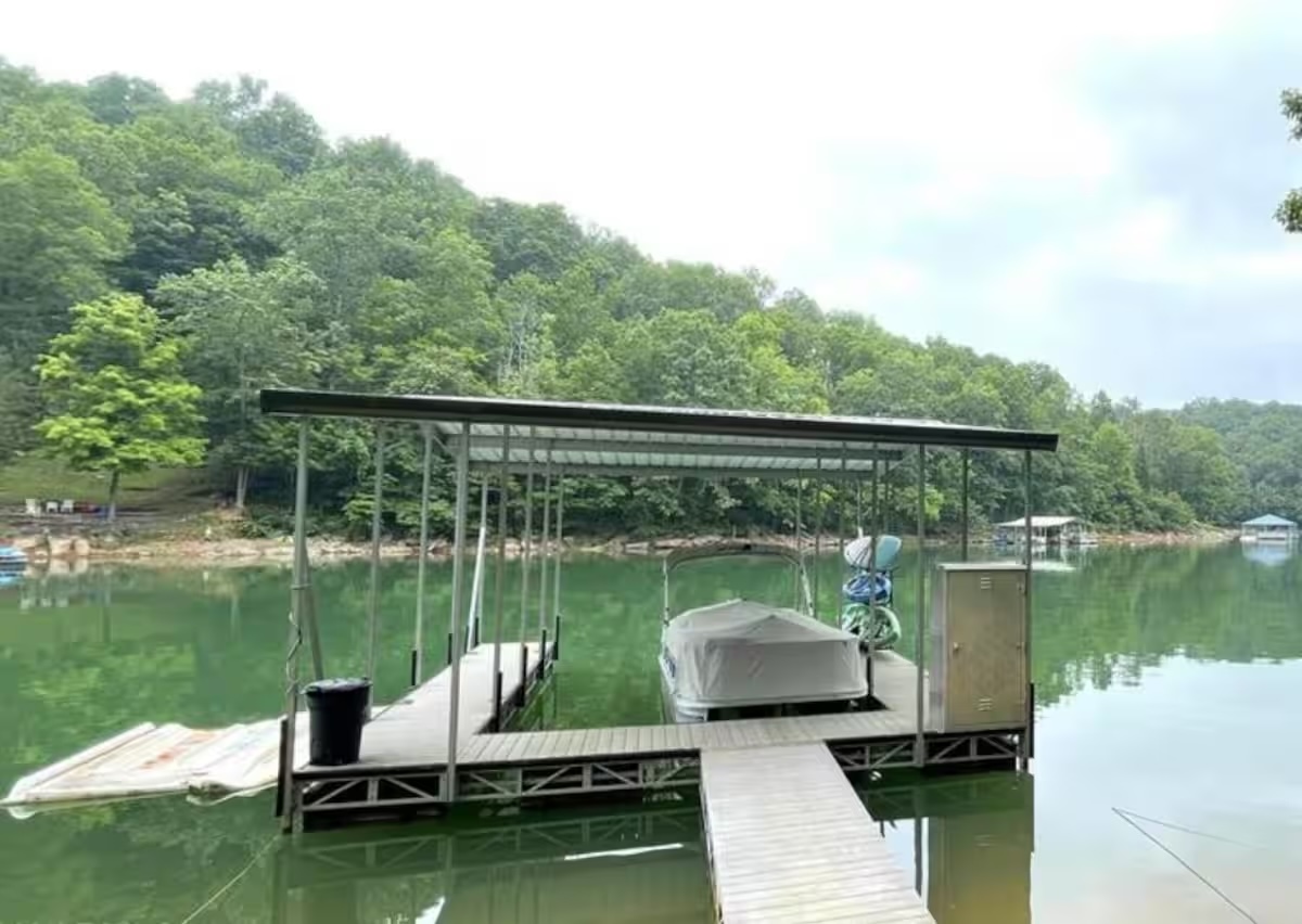 Large covered slip dock with kayaks and paddle board