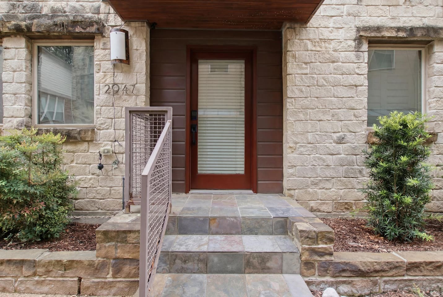 Stone and wood facade on Thomas Avenue in the State Thomas neighborhood. A modern Dallas townhome just minutes from Uptown on foot and the Design District by car.

