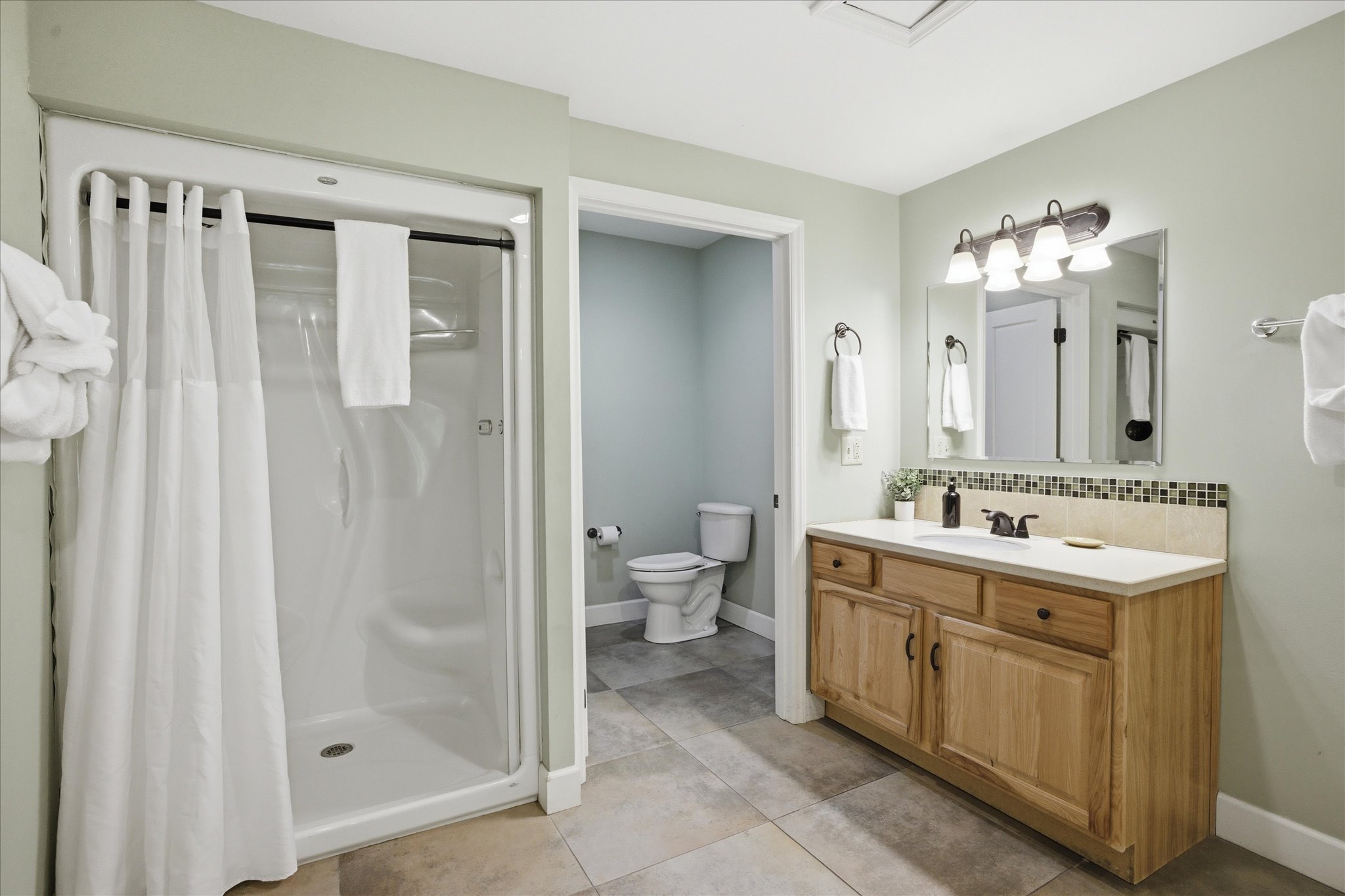 Wind down in the soaking tub or step into the walk-in shower. This bathroom offers ample privacy with a separate toilet room and plenty of drawer and cabinet space. Fully stocked with everything you might need.