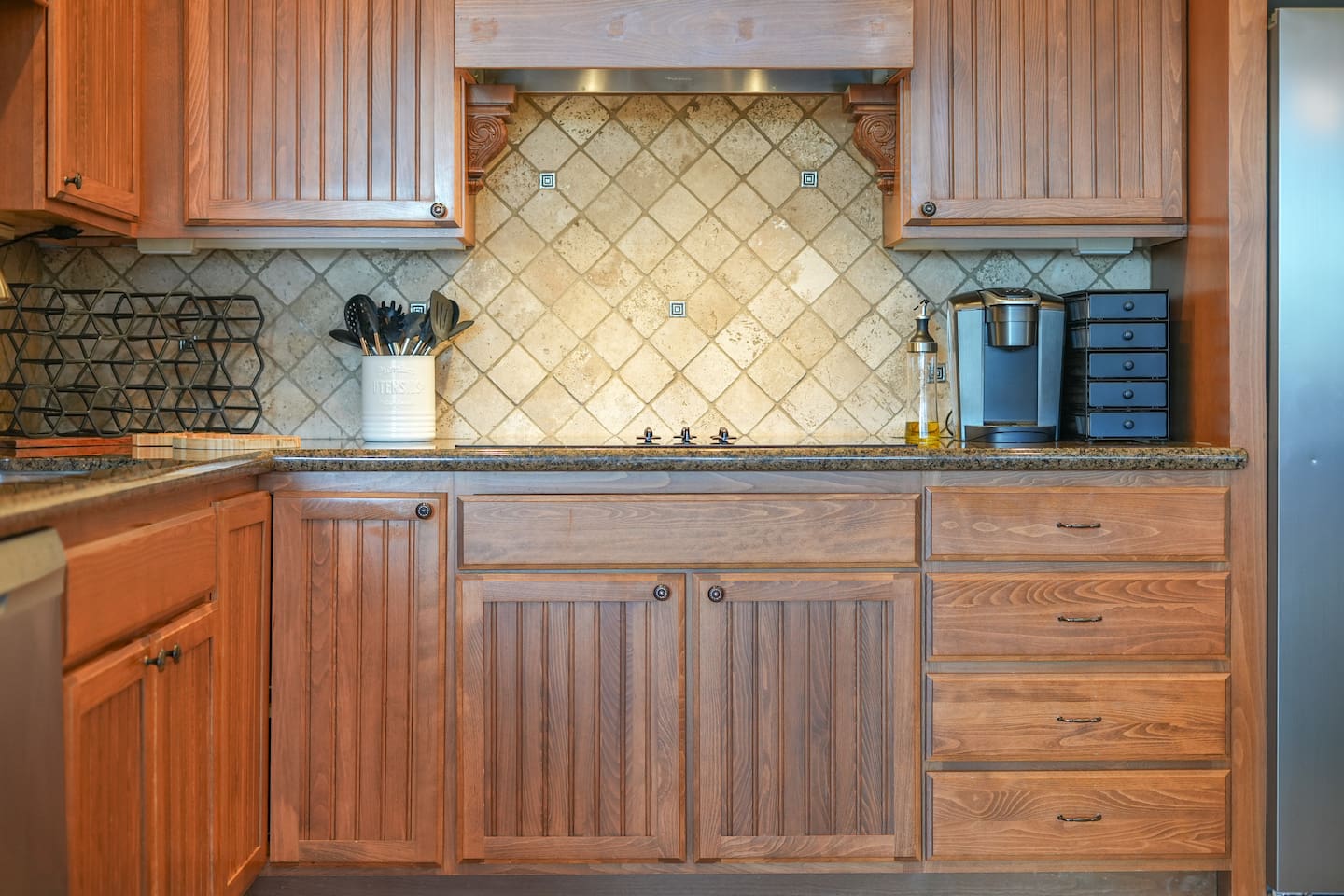Custom range hood and tile backsplash add character to the kitchen.