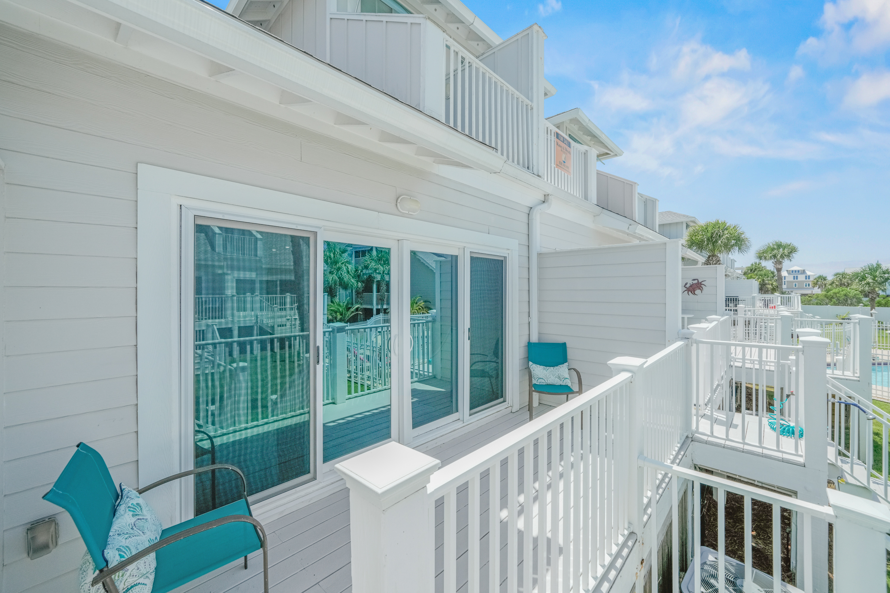 Bright private balcony overlooking the community pool, offering fresh coastal breezes and a relaxing outdoor retreat