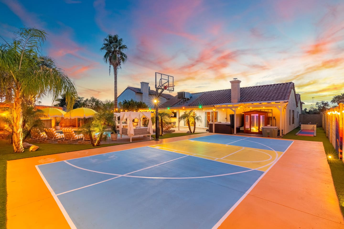 The private basketball court glows under a vivid desert sunset — game time never looked so good.