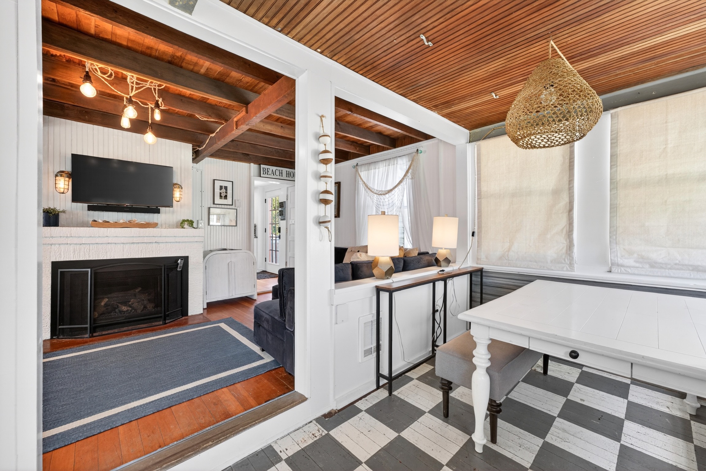 Step into this coastal cottage and you’ll find a welcoming game table and a spacious living room perfect for gathering and relaxing.