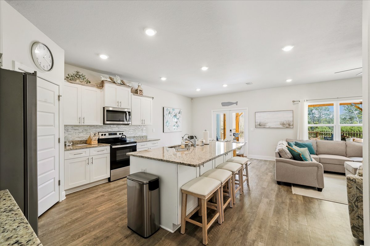 fully stocked with stainless steel appliances and a kitchen island with seating for four.