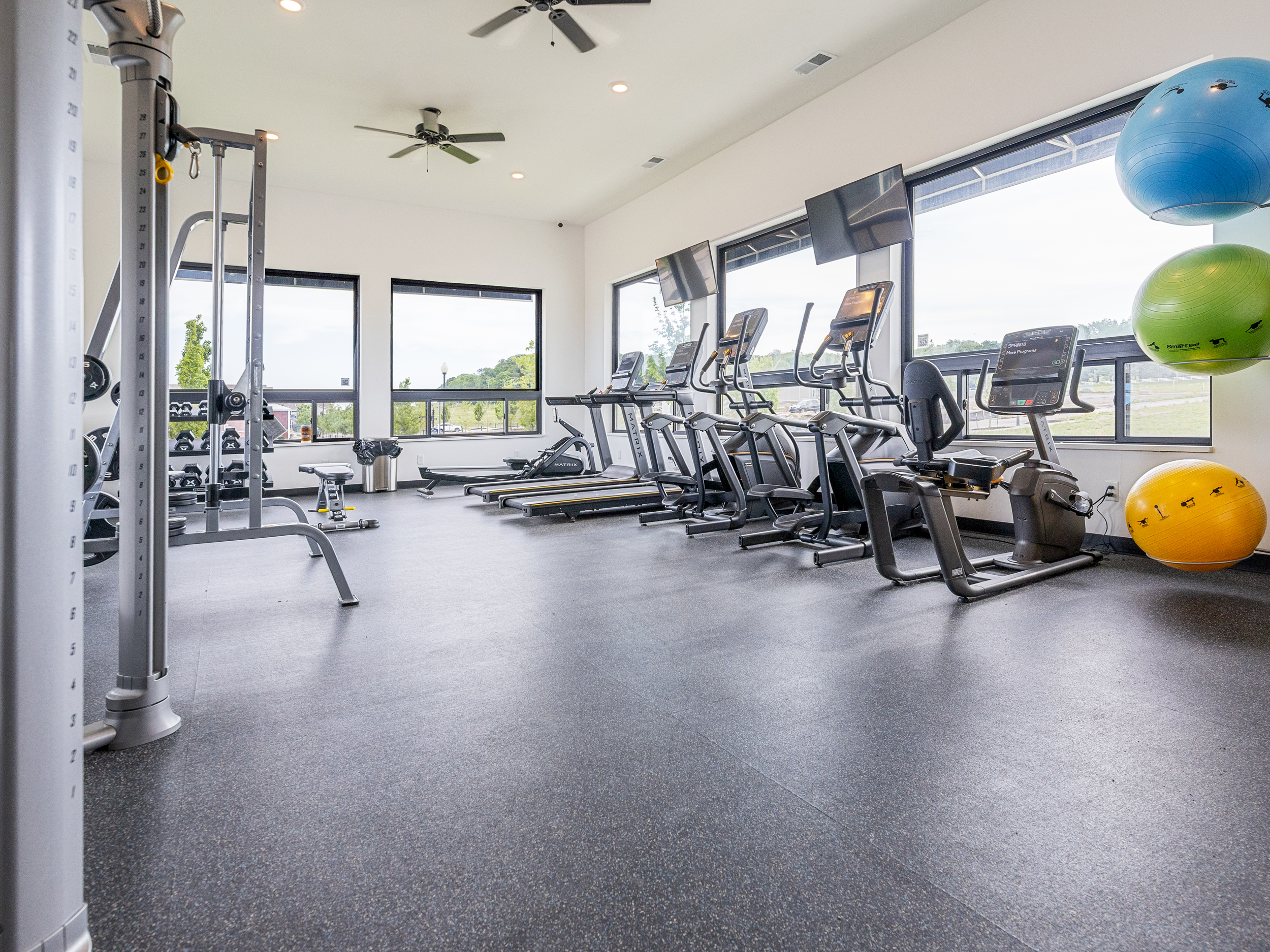 Modern fitness center featuring cardio and strength-training equipment. Membership required and available separately through the facility.