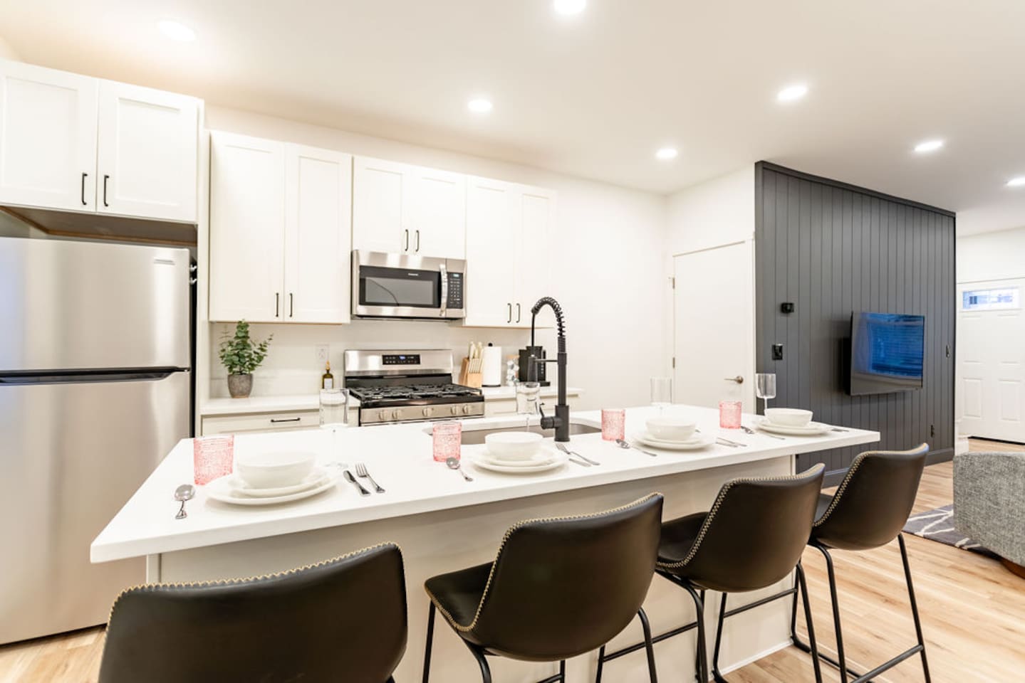 Full view of the dining area with a set of plates, featuring a clear view of the cooking appliances in the kitchen.
