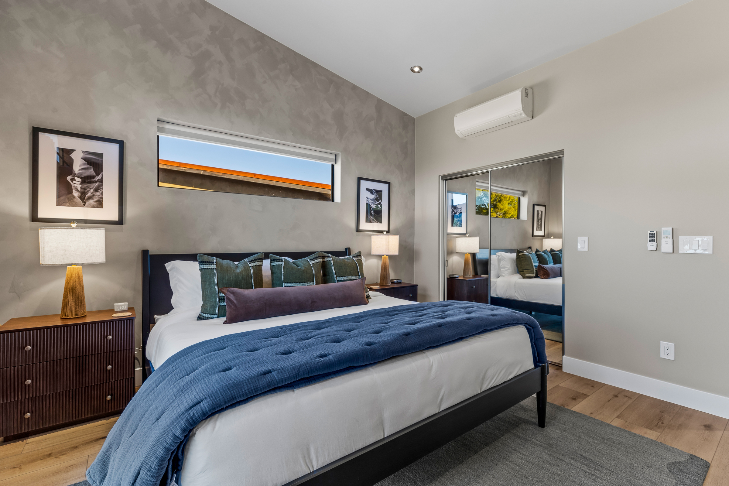A bright, comfortable second bedroom with a well-appointed king bed, soft lighting, and a calm design - ideal for additional guests or couples.