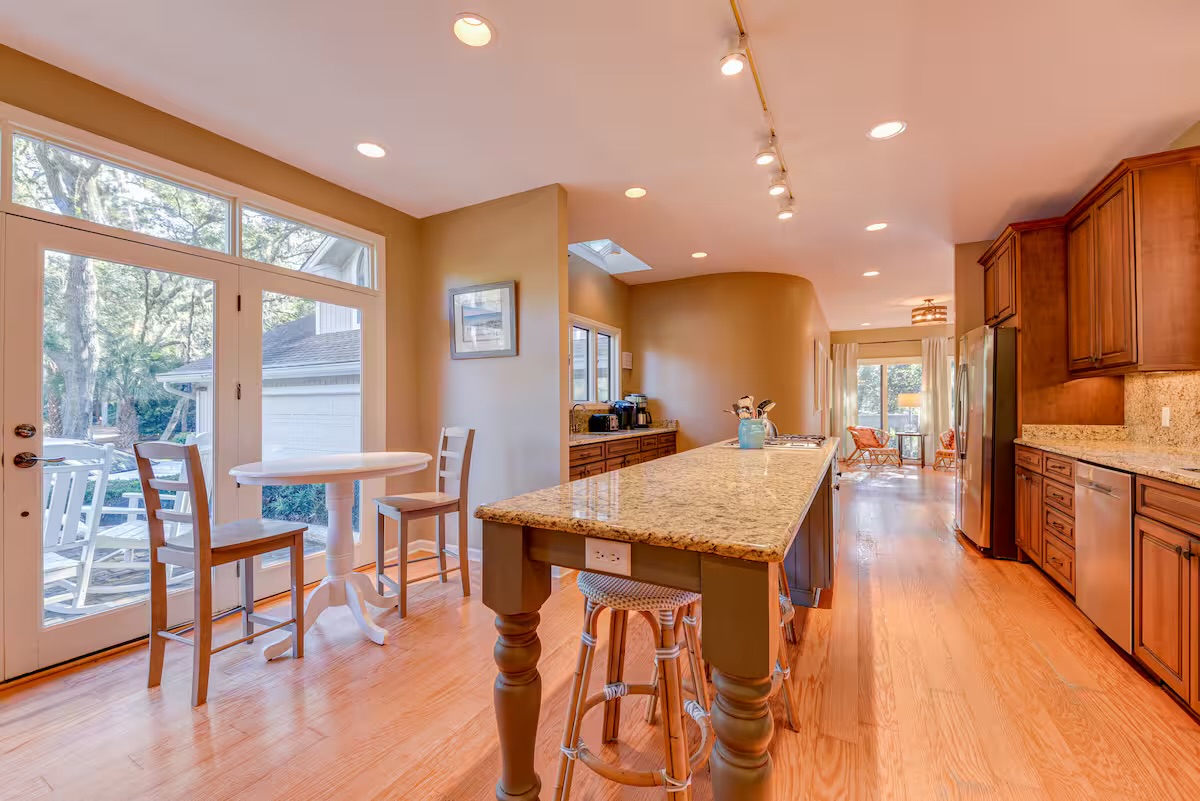 Kitchen looks out to deck, pool and #11 green of Heron Pointe