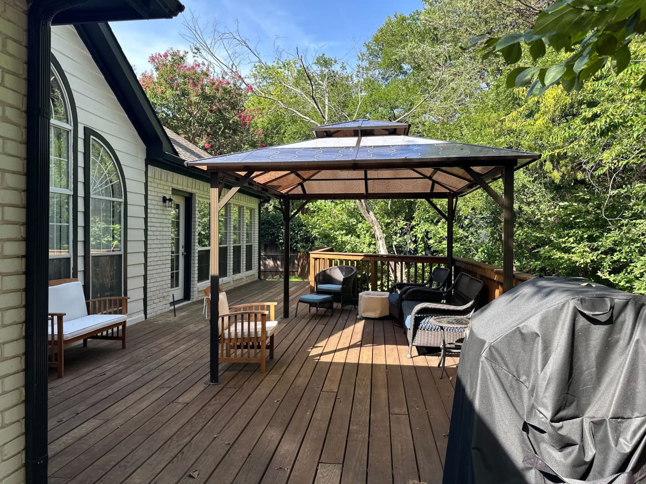 Covered patio with grill for outdoor dining and entertaining.