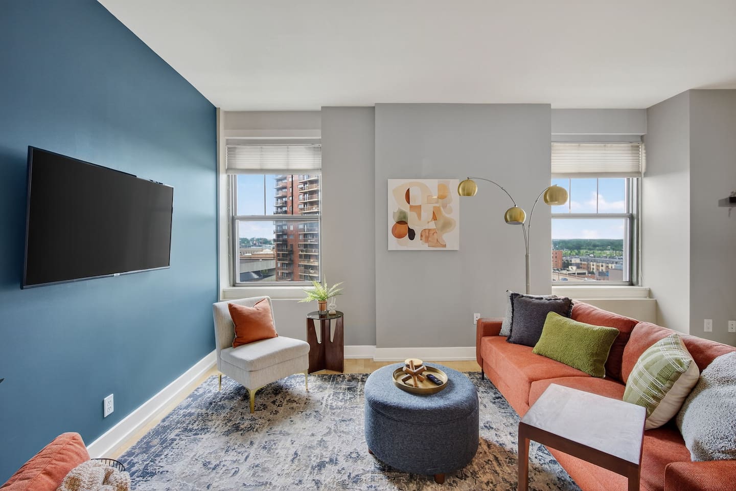 Gather in a stylish living room with skyline views, modern decor, and a bold accent wall. Sink into the vibrant sofa, stream your favorites on the flat-screen TV, or enjoy conversation bathed in natural light; perfect for city escapes.