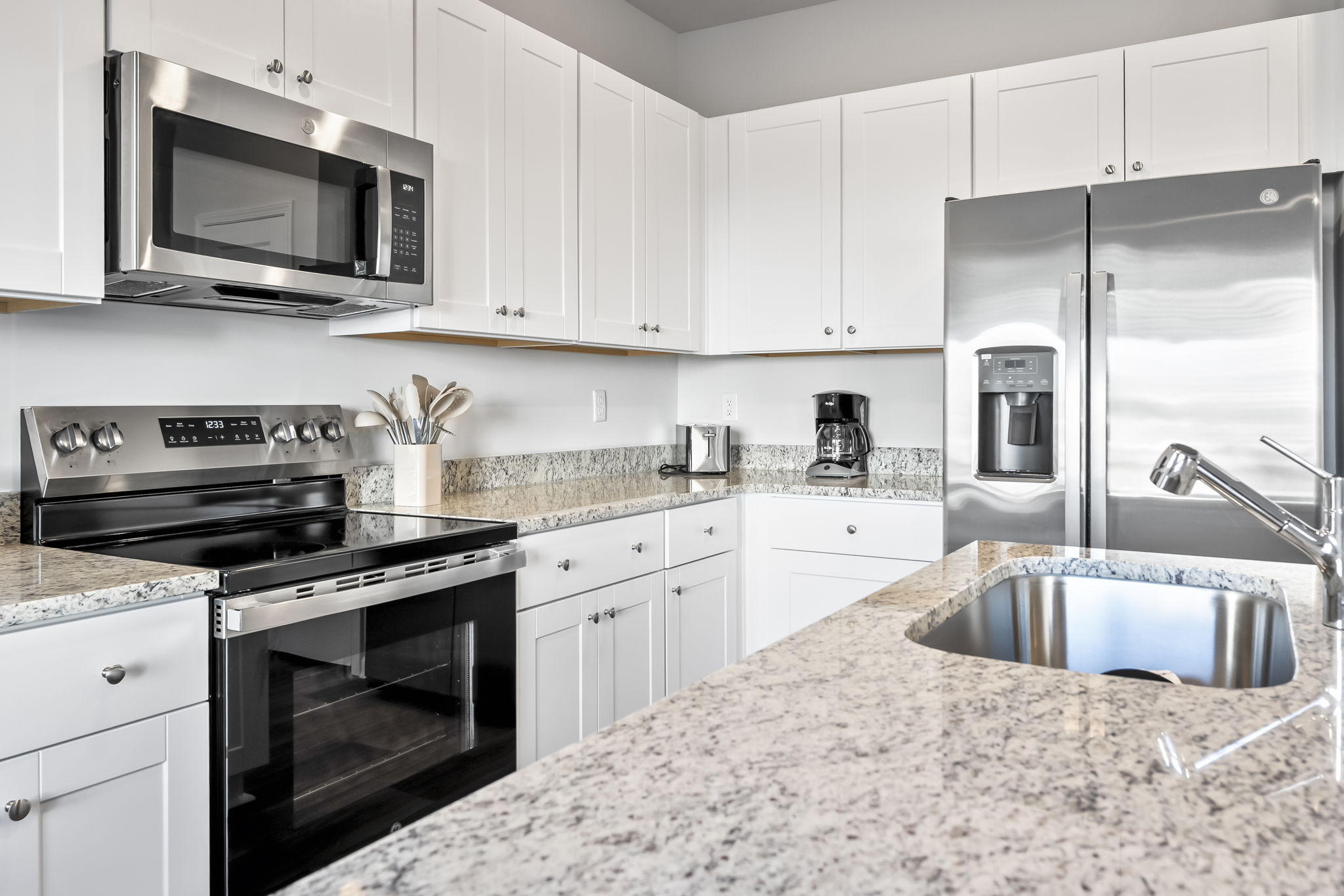 New kitchen with stainless steel appliances and granite countertops