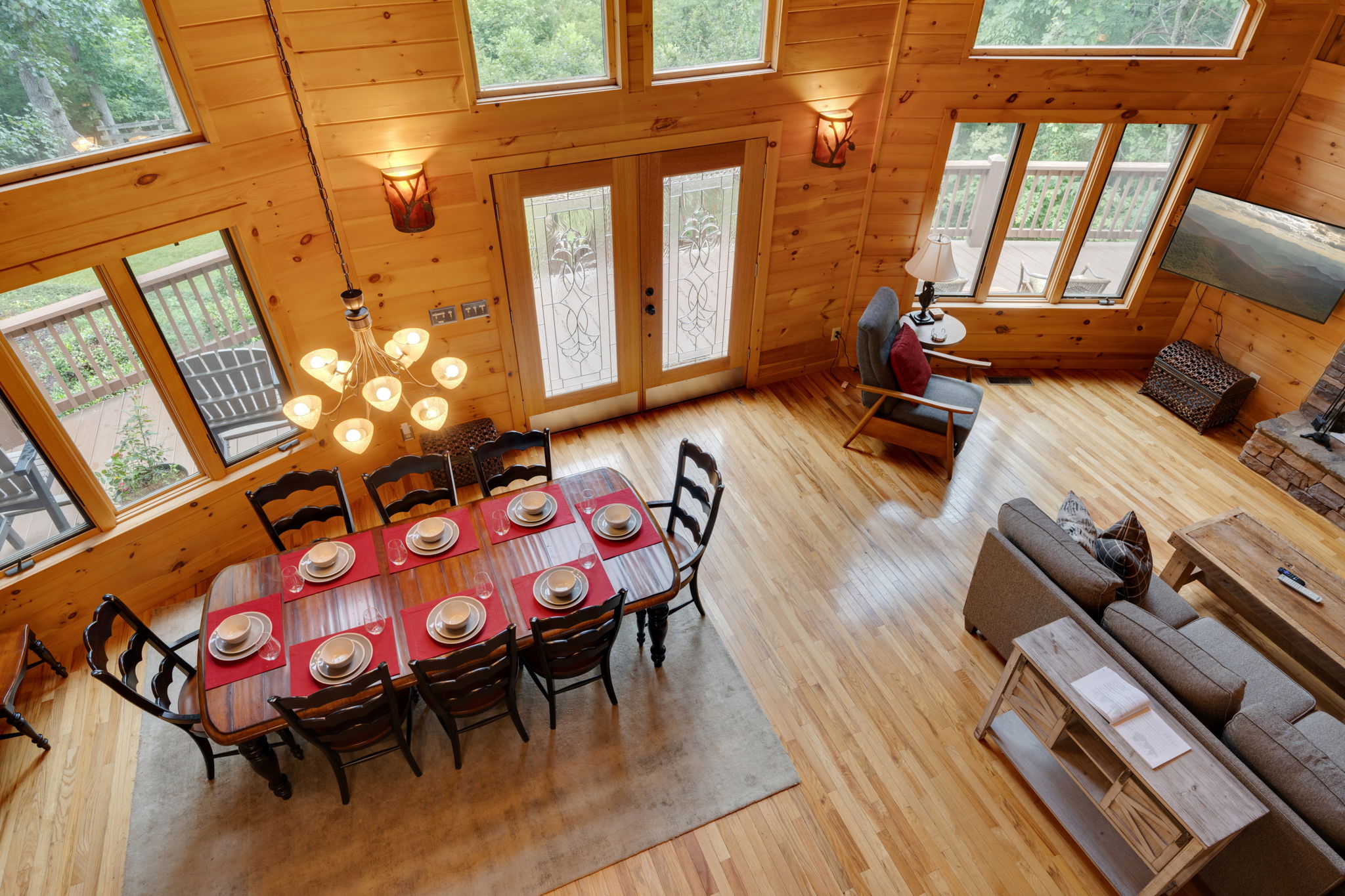 View from the loft of the dining room, living room, and outdoors through all the windows.