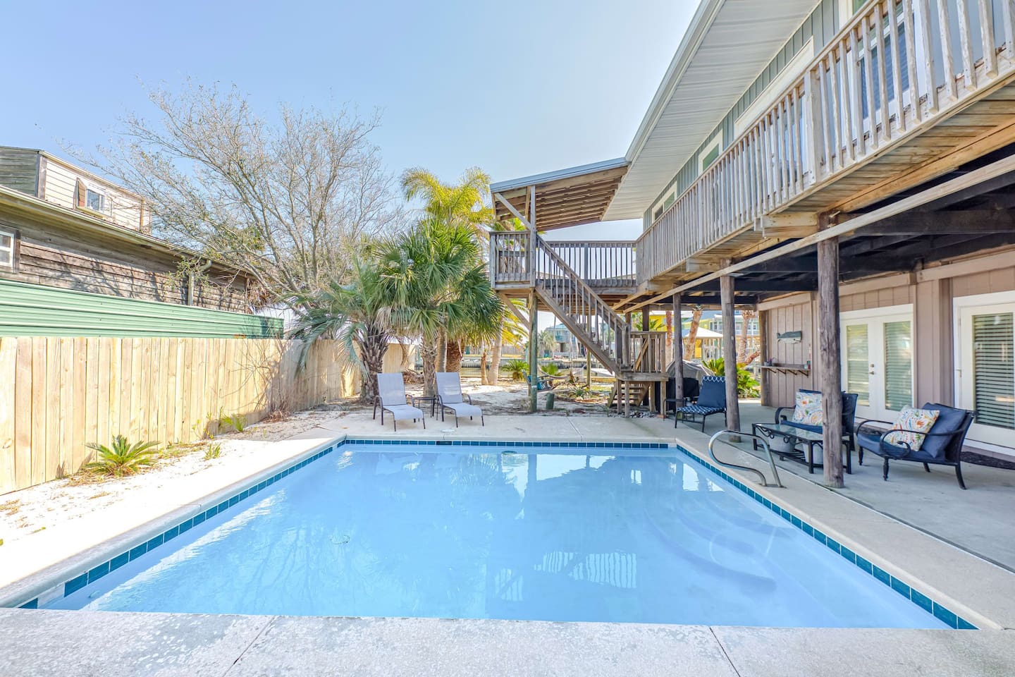 Outdoor Oasis: Dive into relaxation by your private pool surrounded by palm trees in Fort Morgan!