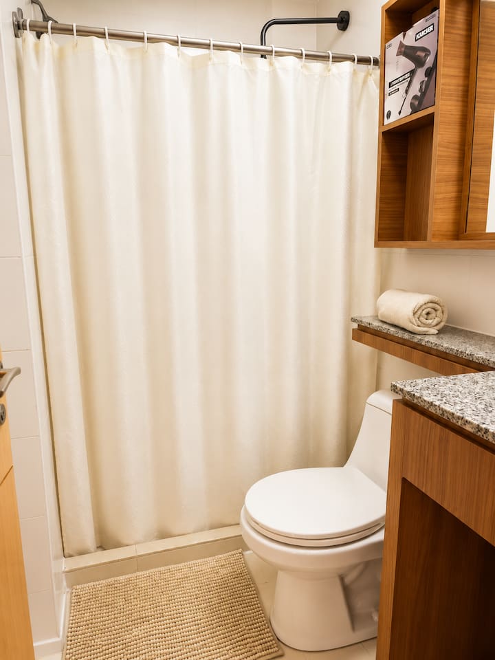 Bathroom 2, featuring a spacious shower area and stylish vanity storage.