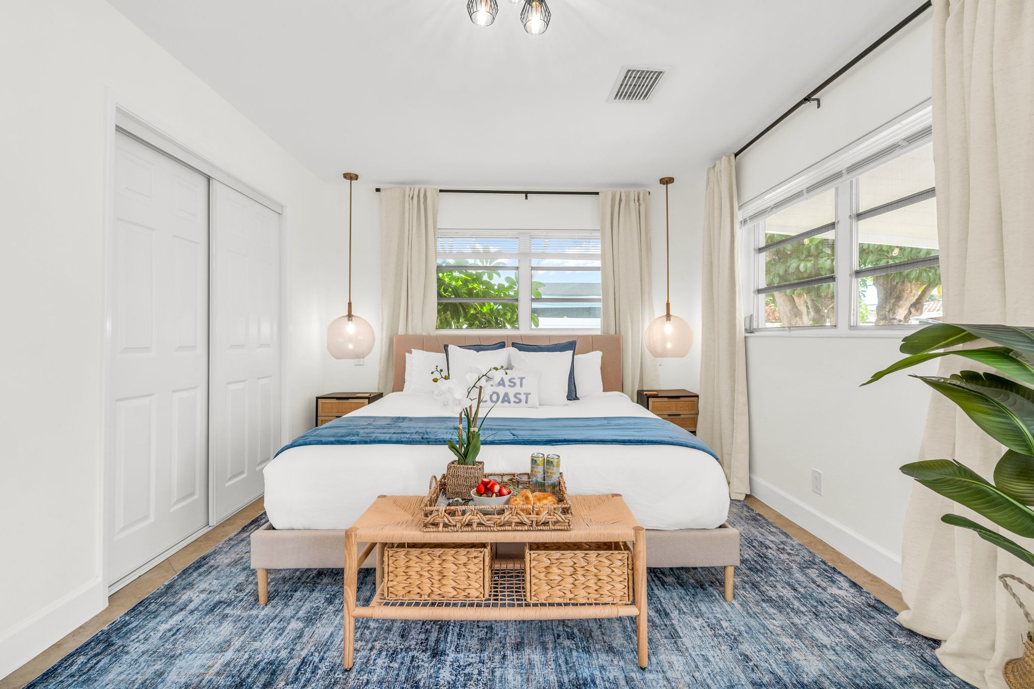 A bright and inviting primary suite featuring a hotel-quality king bed, dramatic pendant lighting, a sleek ensuite shower bath, and a Smart Fire streaming TV—your perfect private sanctuary.