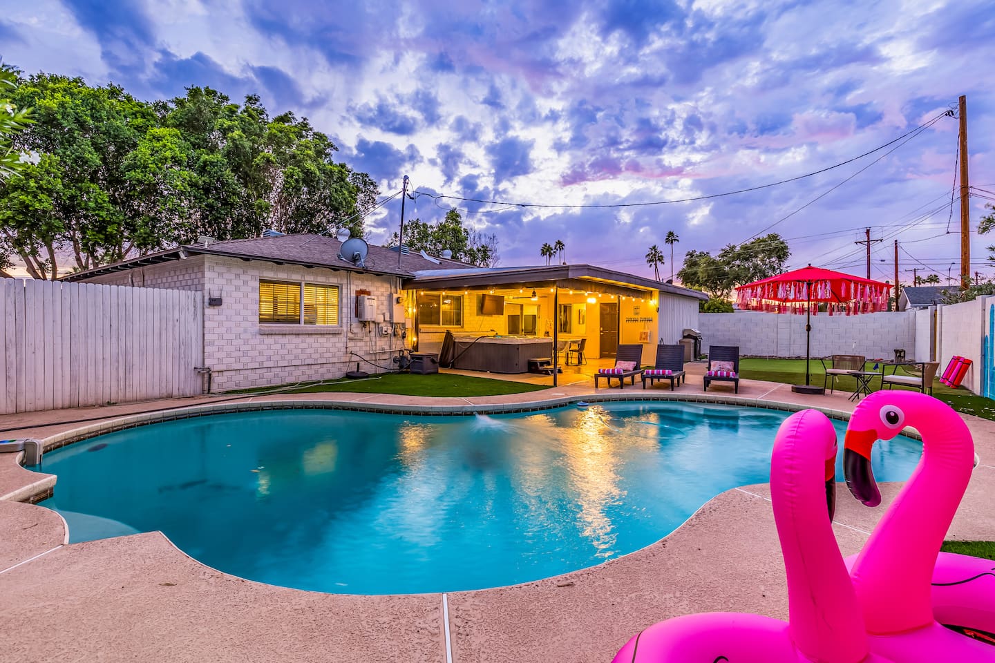 Enjoy golden hour views from your private Scottsdale backyard, complete with a heated pool, loungers, hot tub, and string-lit patio.

