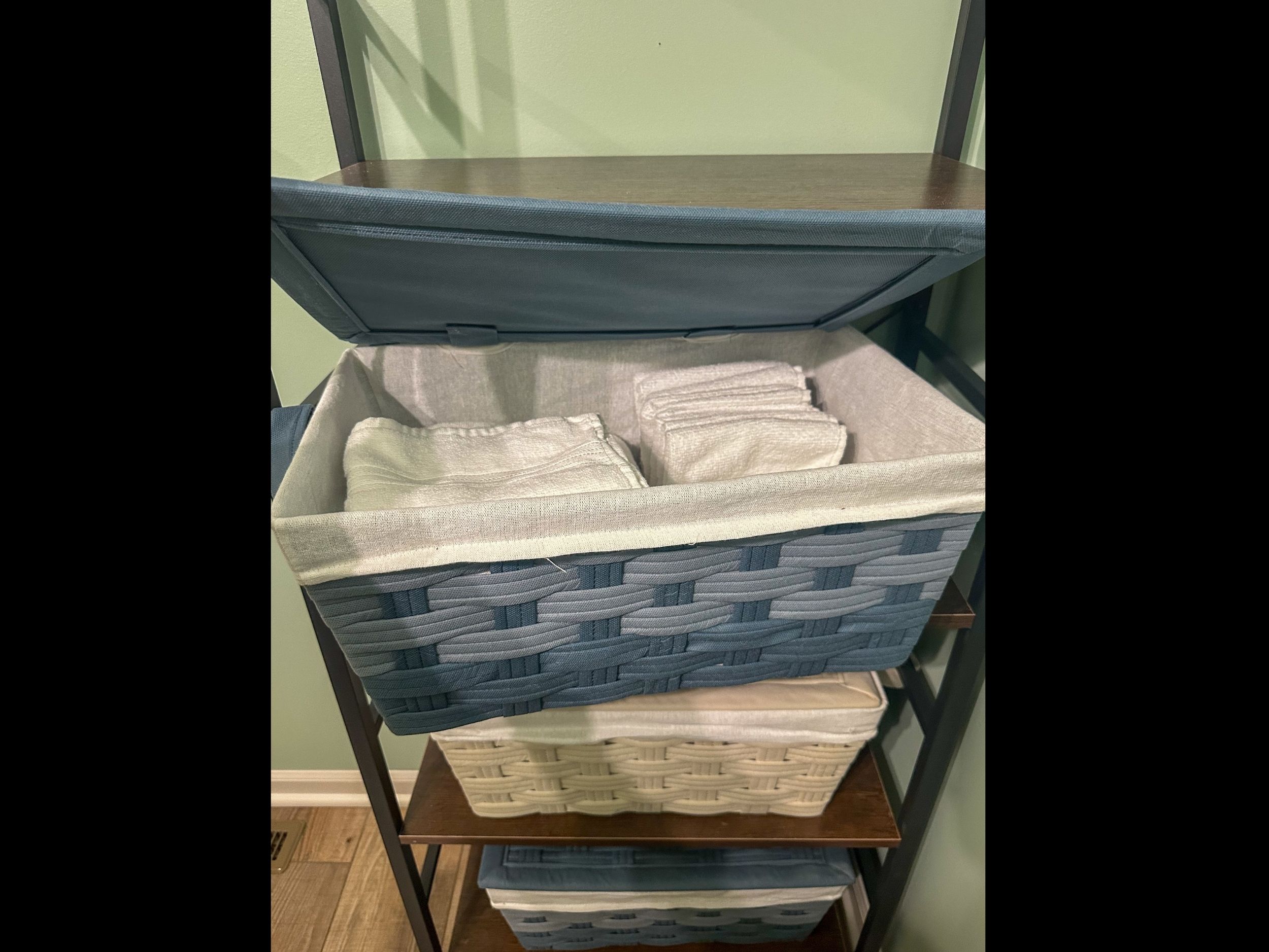 Half bath shelving with neatly folded hand towels and washcloths, keeping essentials within easy reach.