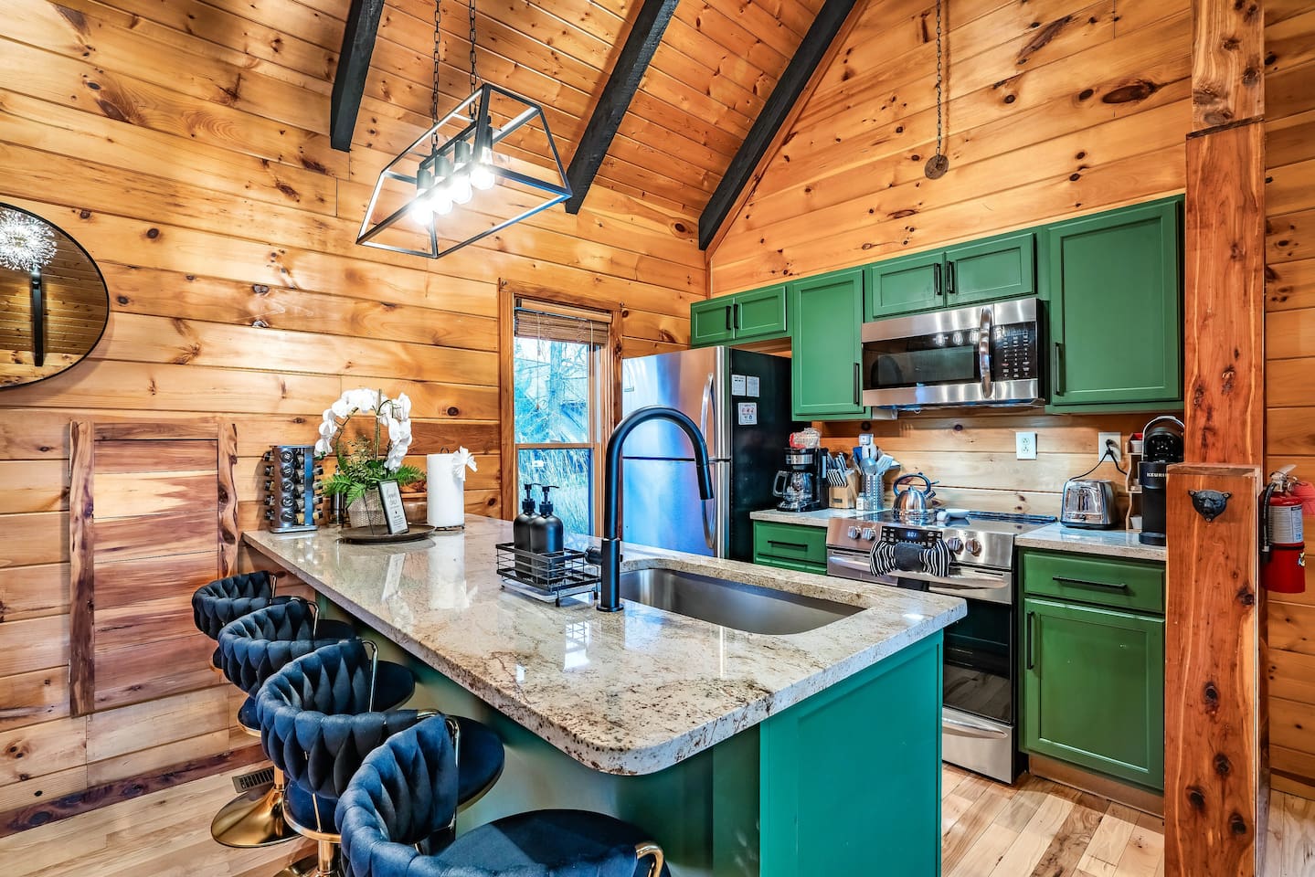 Warm and welcoming cabin kitchen with sleek countertops and bar seating, perfect for enjoying home-cooked meals in a serene mountain getaway.
