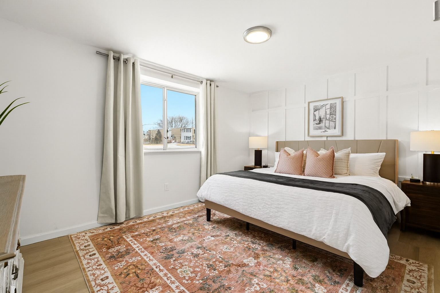 Sleep in style with a king-size bed, plush pillows, and elegant matching lamps.