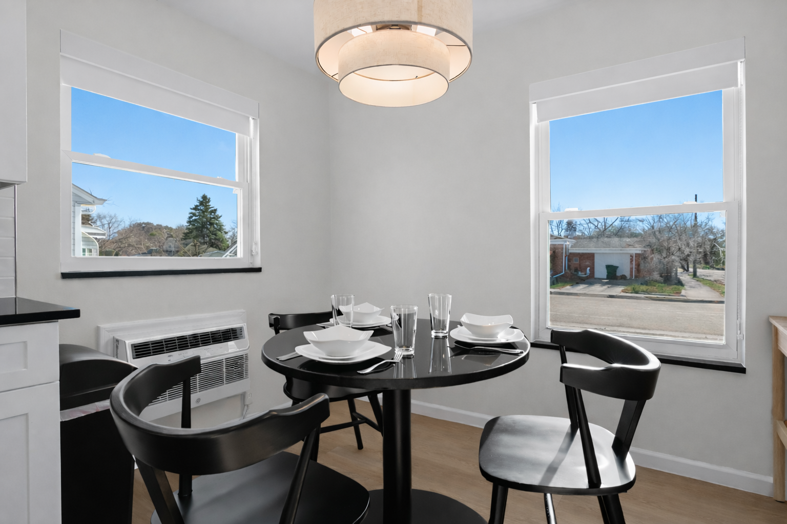 Sun-filled dining nook with modern table setting, stylish chairs, and soft pendant lighting—an inviting spot for meals, coffee, or conversation.