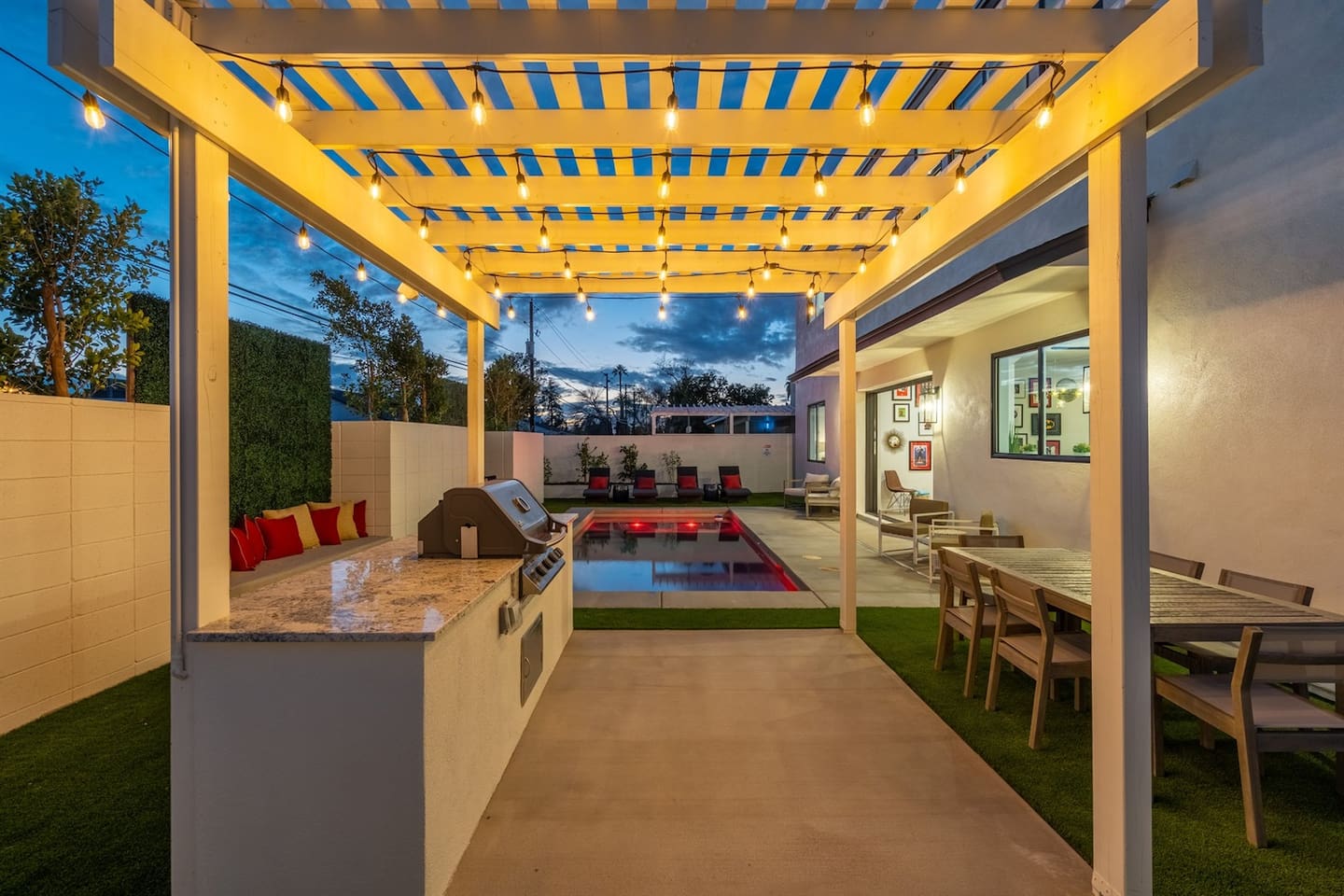 The beautifully designed pergola features a grill and preparation area, complemented by a spacious dining area, making it perfect for outdoor cooking and entertaining.