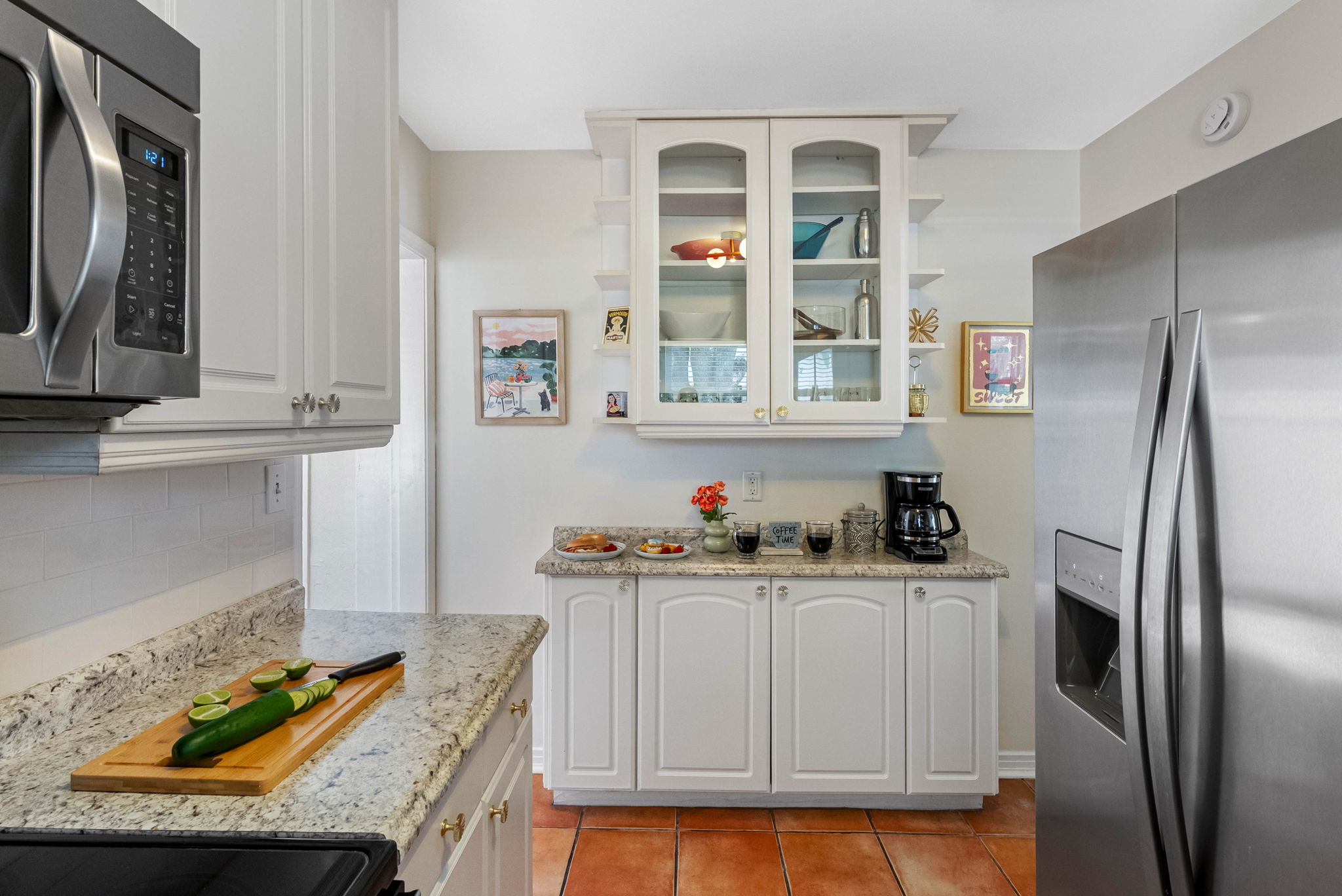 Durable granite countertops and a clean white subway tile backsplash make cleanup a breeze and provide a sleek, polished look.