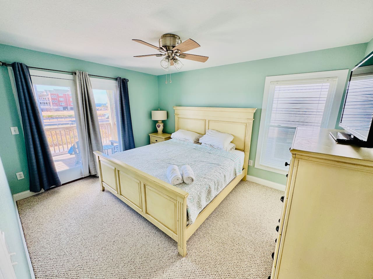 Bright King bedroom with Smart TV and direct deck access.