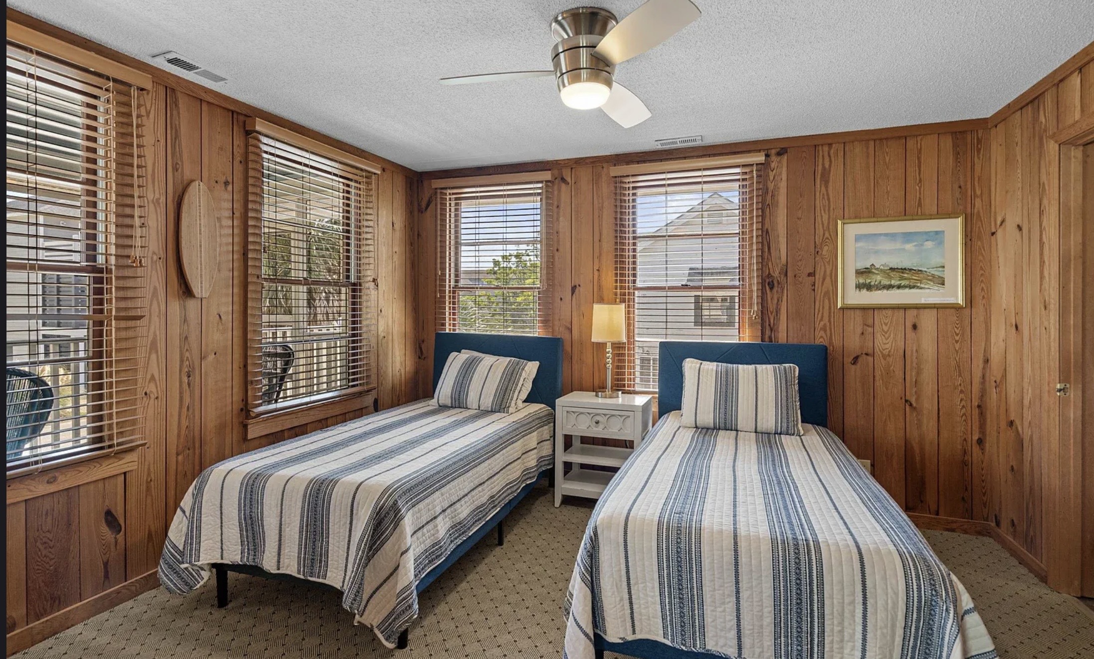 A comfortable upstairs bedroom with a ceiling fan and that easy coastal warmth. ⭐