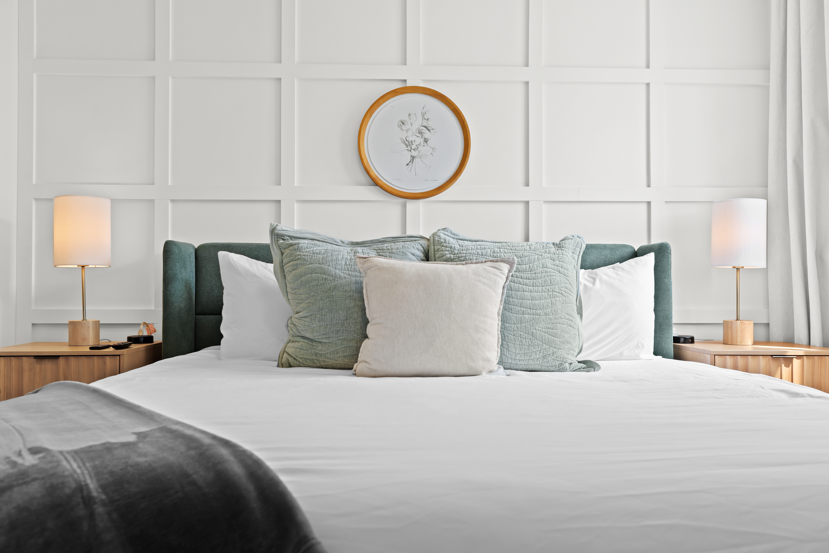 This cozy king suite offers soft linens, blackout curtains, and a touch of elegance with a decorative wall treatment.