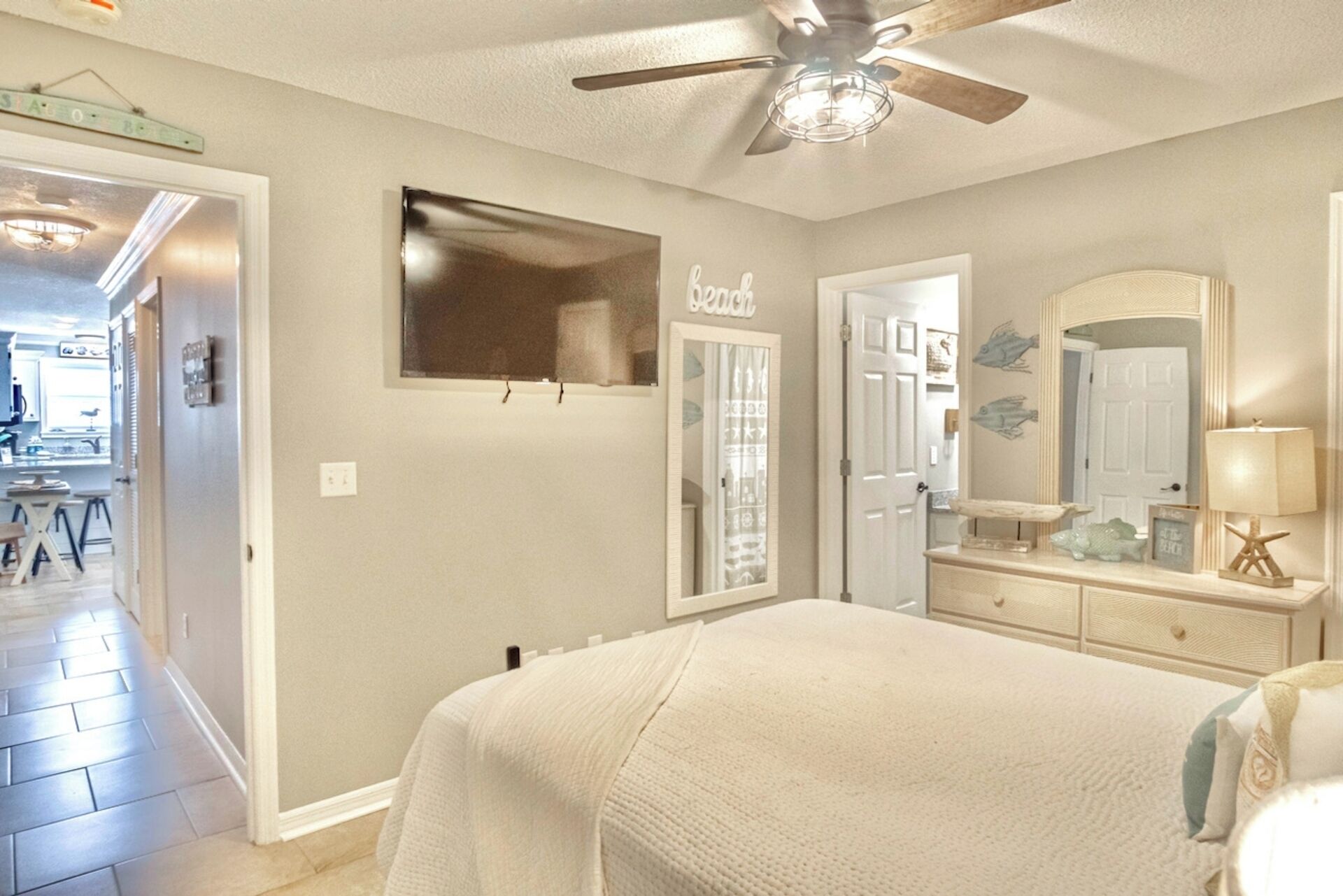 Master bedroom with queen bed, smart TV, ceiling fan, and ensuite bathroom