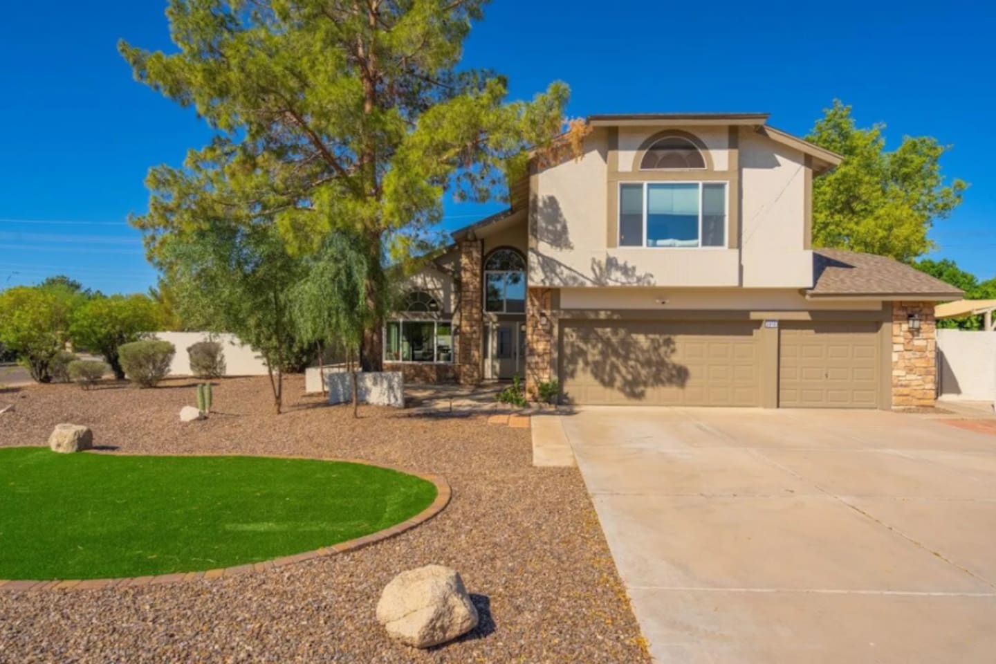 Spacious contemporary home with mature landscaping, desert-style grounds, and open floor plan.