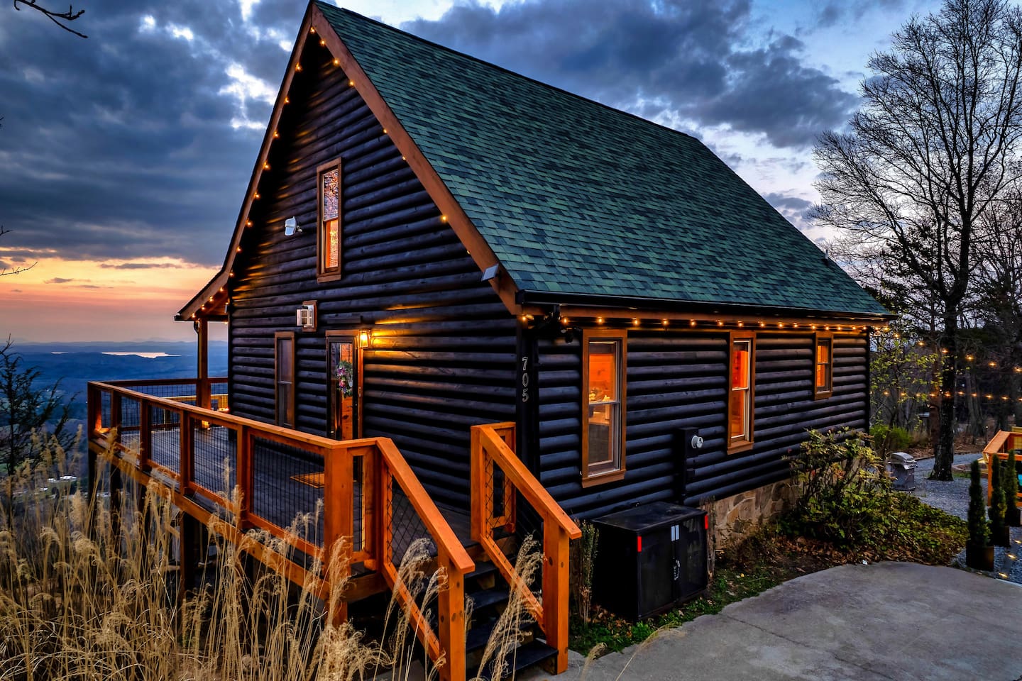 Welcome to Chasing Sunset Cabin. A striking black-painted mountain cabin exterior blending modern design with cozy charm, perfect for a stylish and serene mountain retreat.
